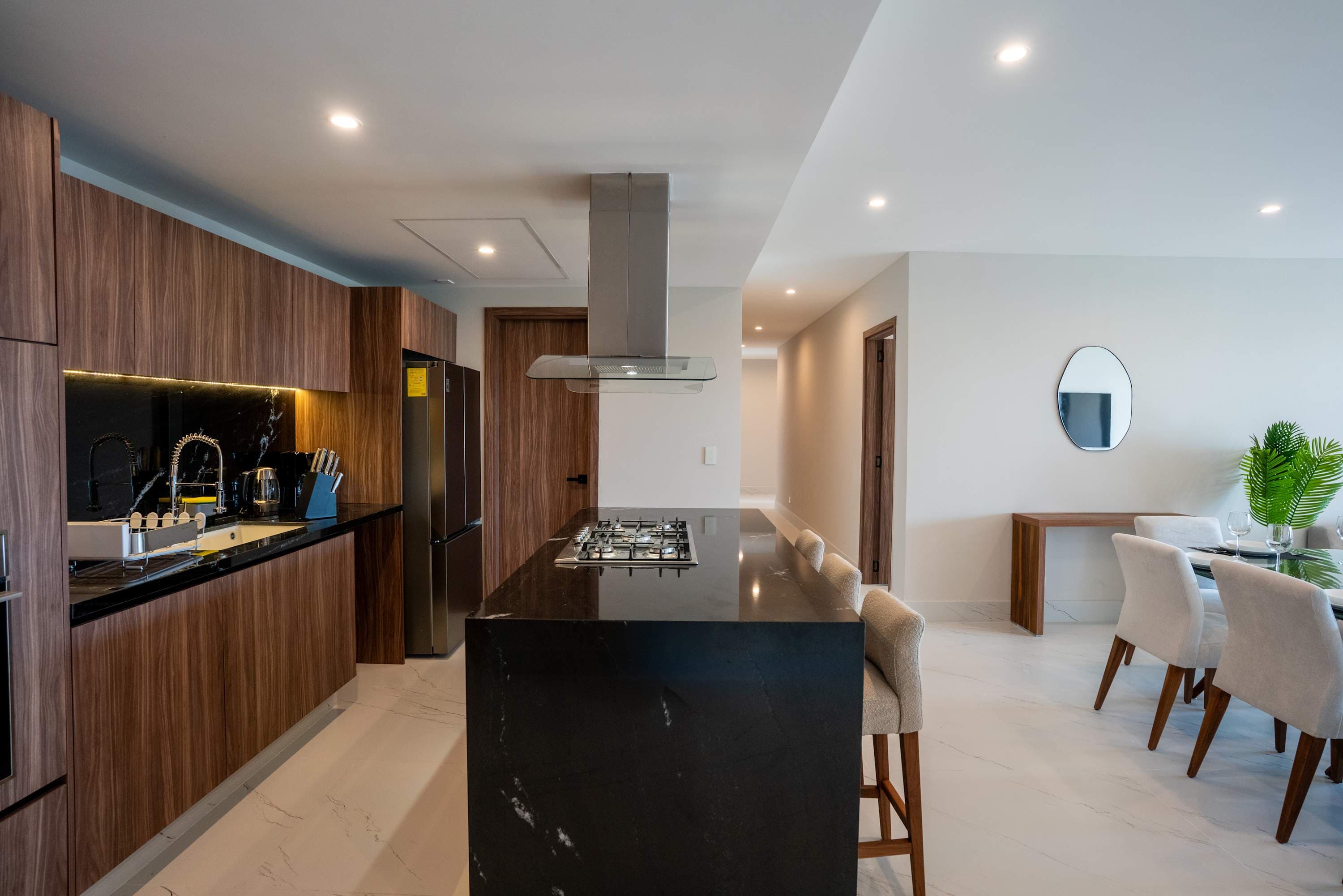 Modern kitchen with island, dining table, and elegant decor.