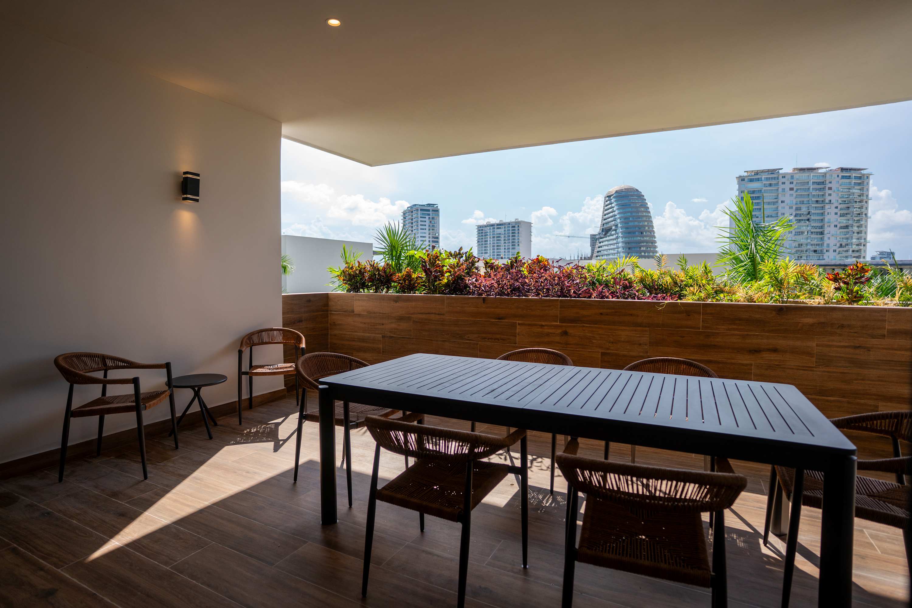 Outdoor dining area with chairs, a table, and city buildings in the background.