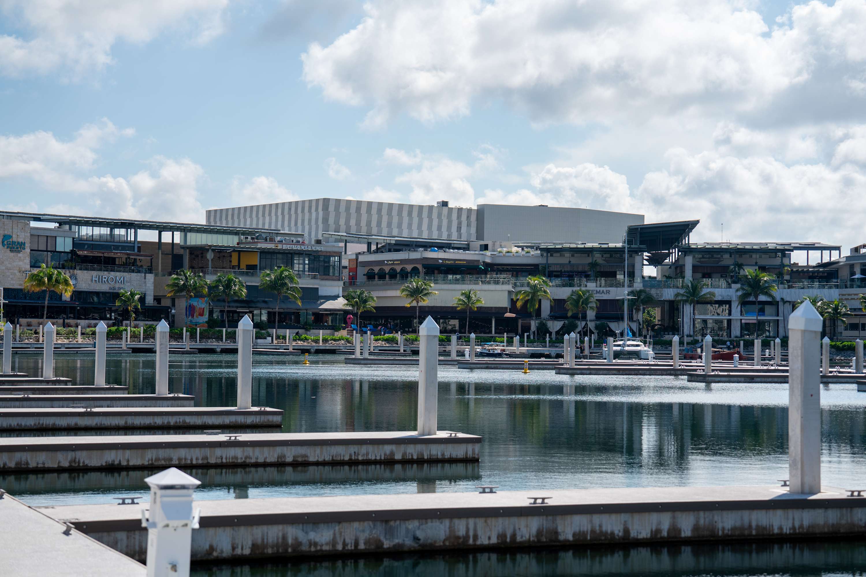 Marina with buildings and boats under a cloudy sky.