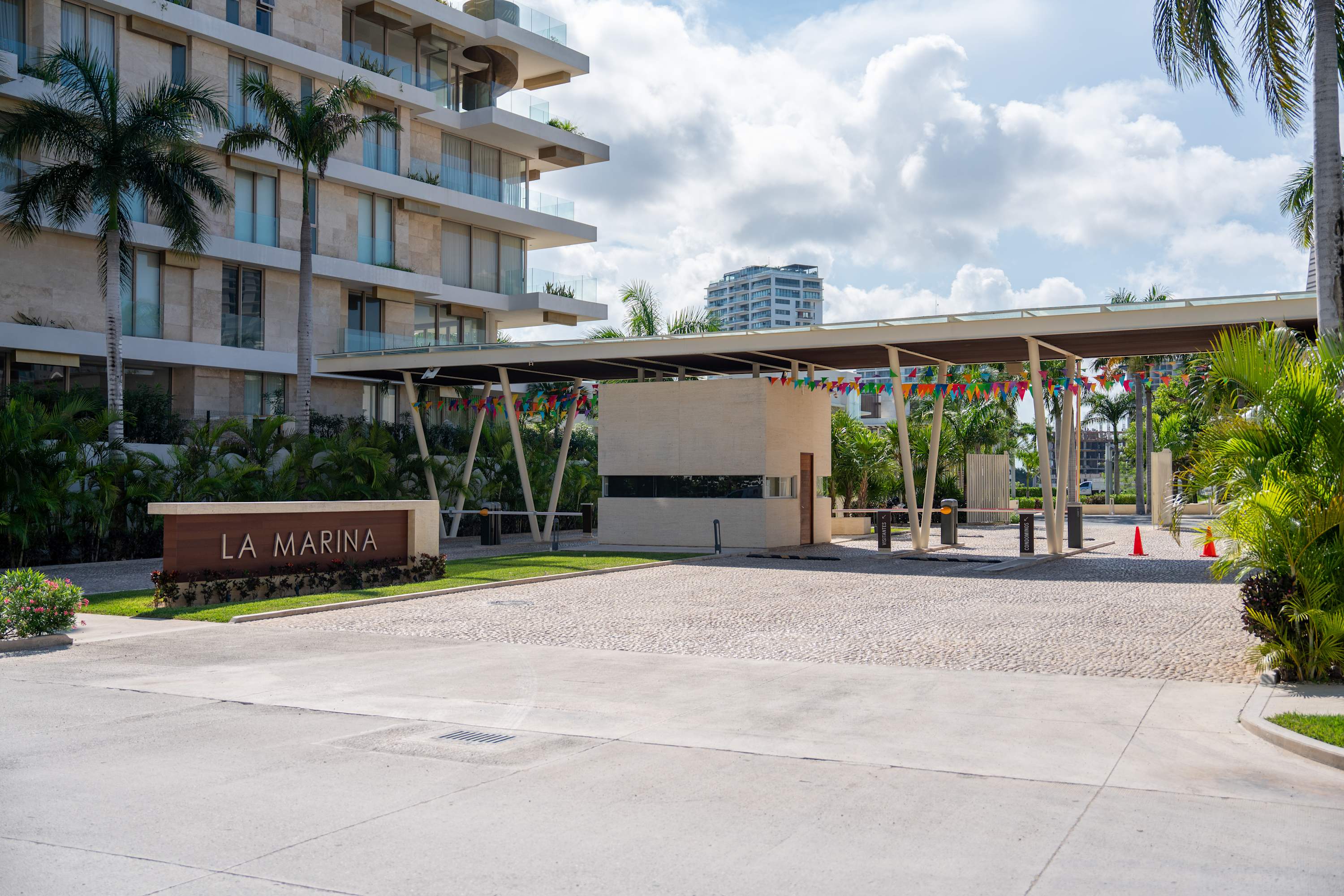 A gated entrance to La Marina building complex, with flags strung across the entrance.
