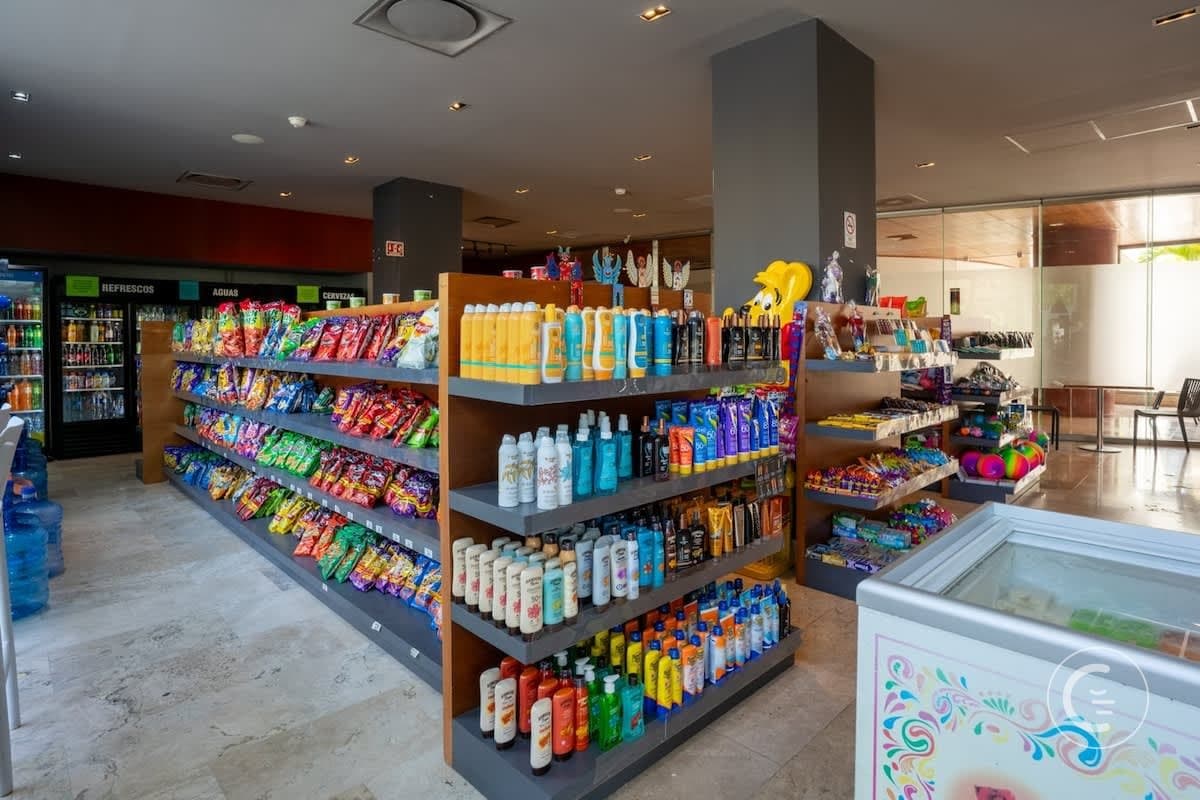 A small convenience store with shelves full of snacks, drinks, and toiletries.