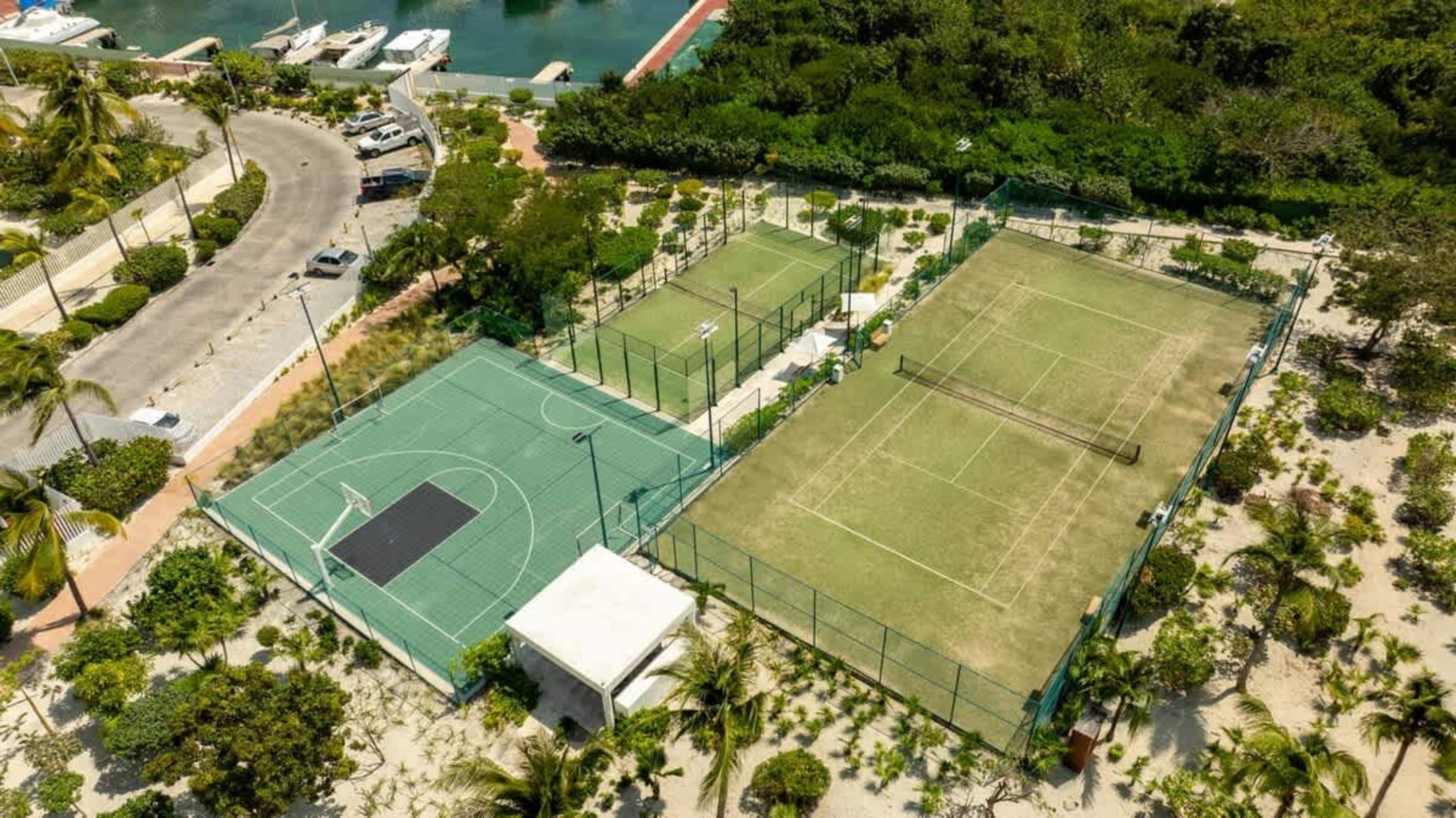 Aerial view of sports courts and a waterfront resort.