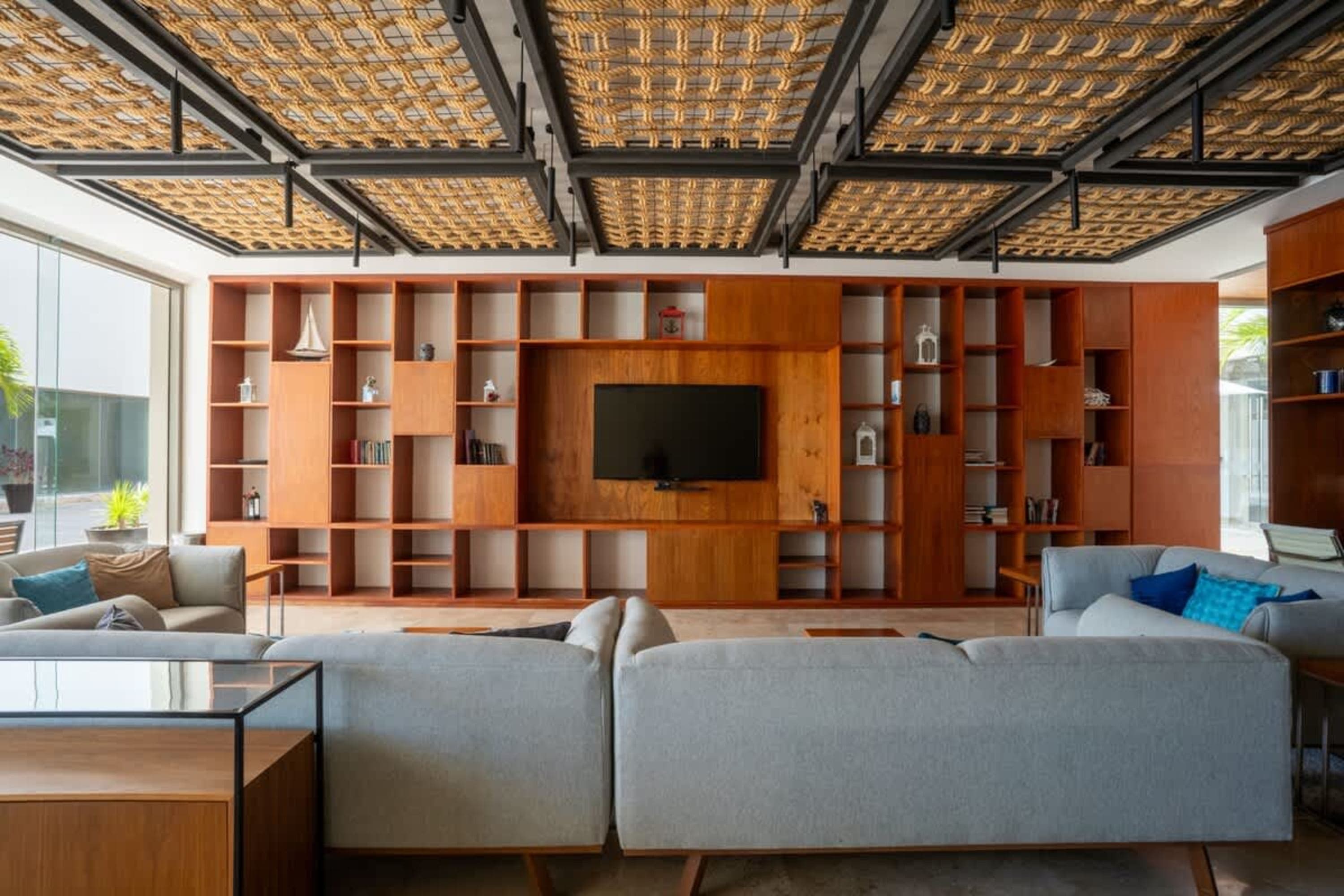 Modern living room with a large wooden bookshelf and a TV.