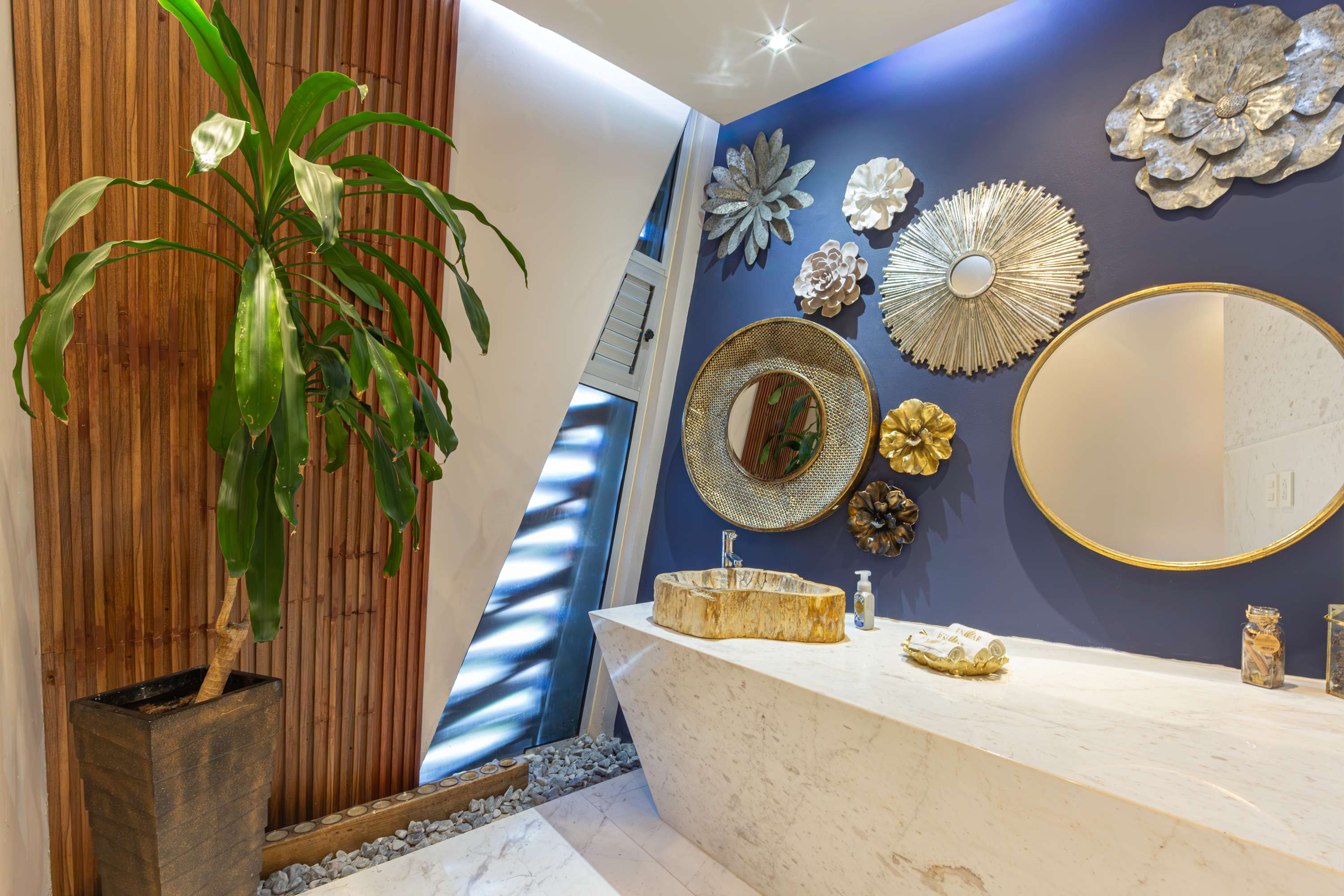 Modern bathroom with wooden accents, a unique sink, and decorative wall art.