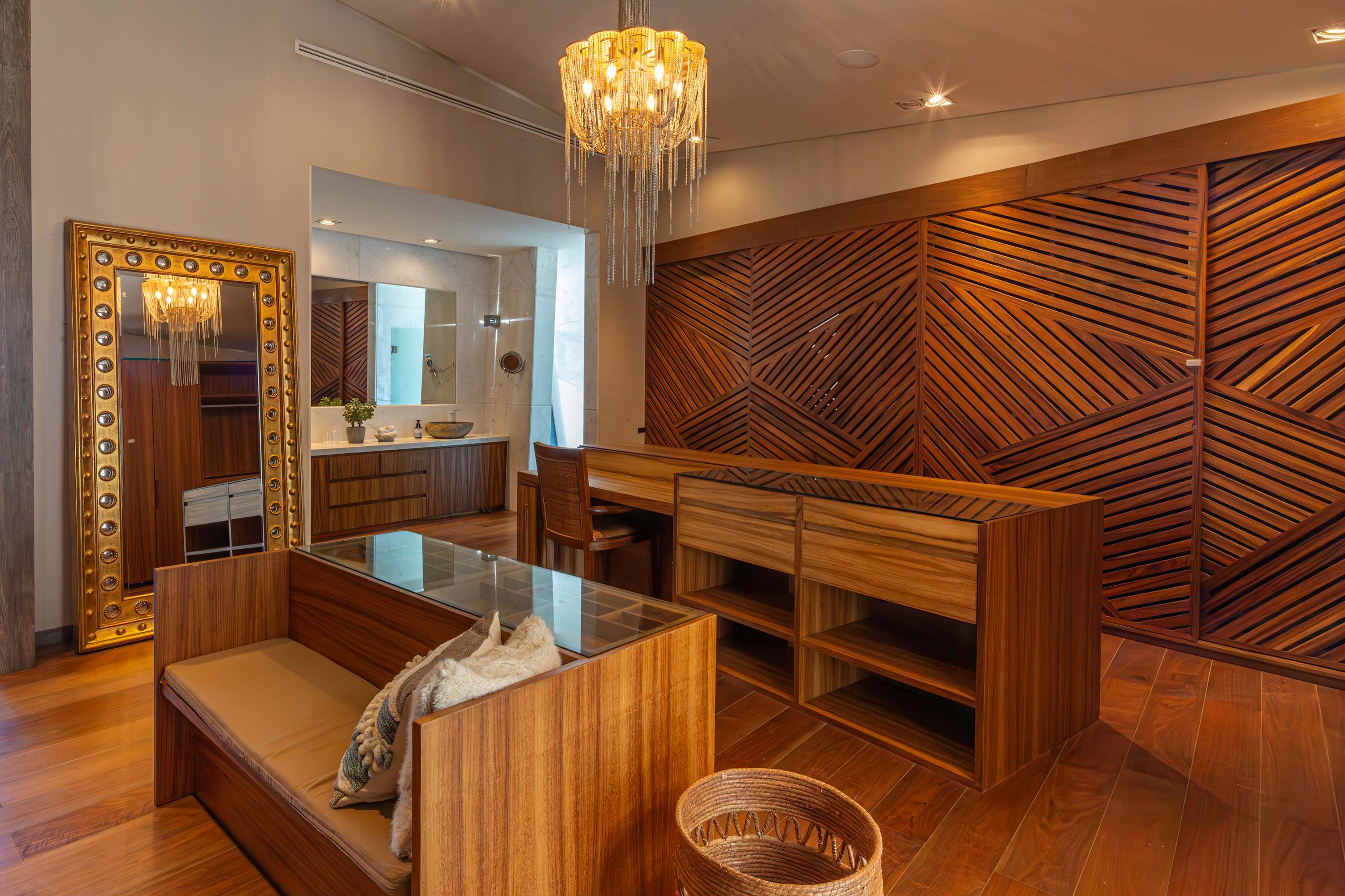 A large, ornate gold mirror reflects a contemporary dressing room with wooden walls and fixtures.