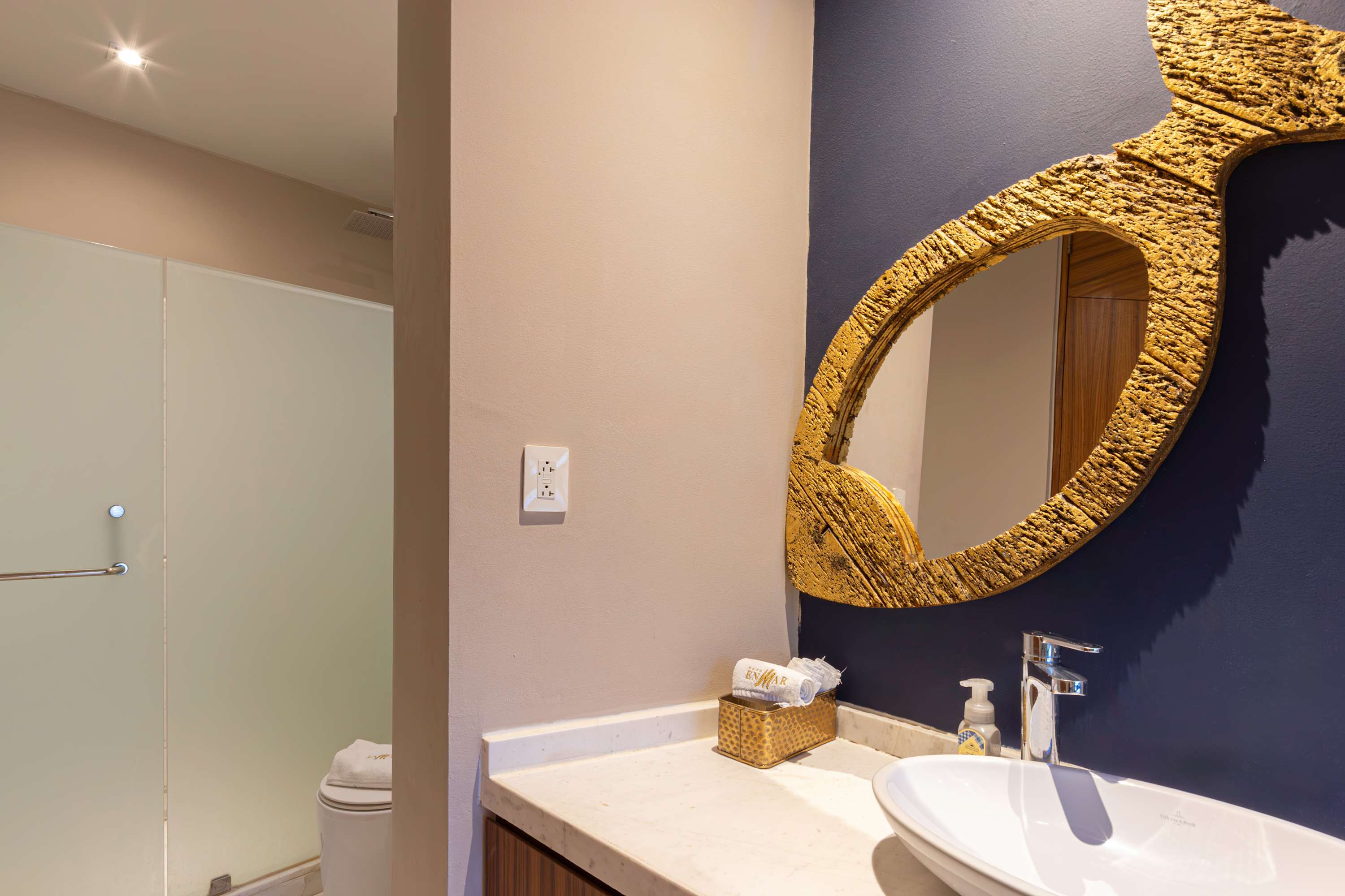 Bathroom vanity with a fish-shaped mirror, sink, and toiletries.