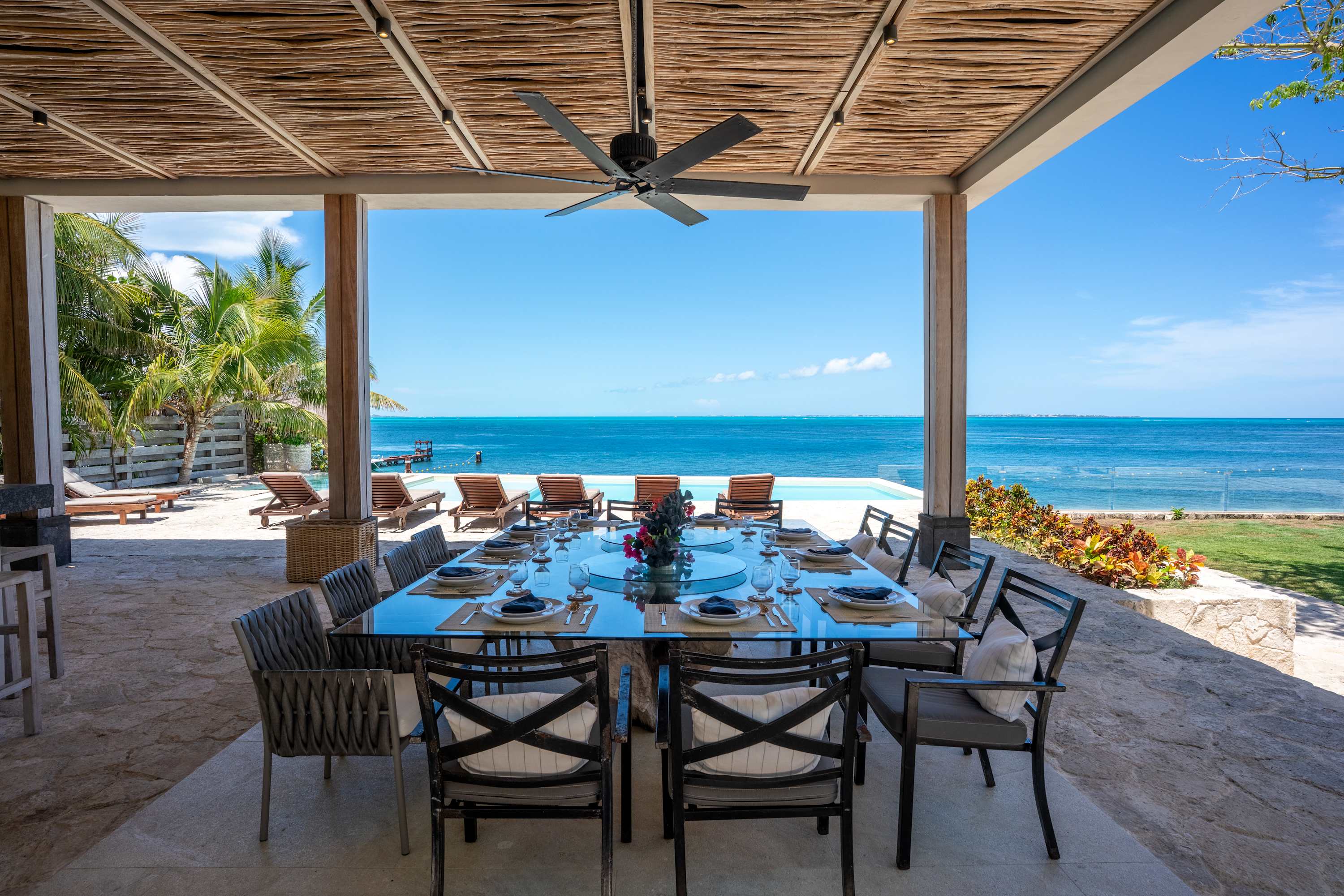 Outdoor dining table set for a meal with a beautiful ocean view.