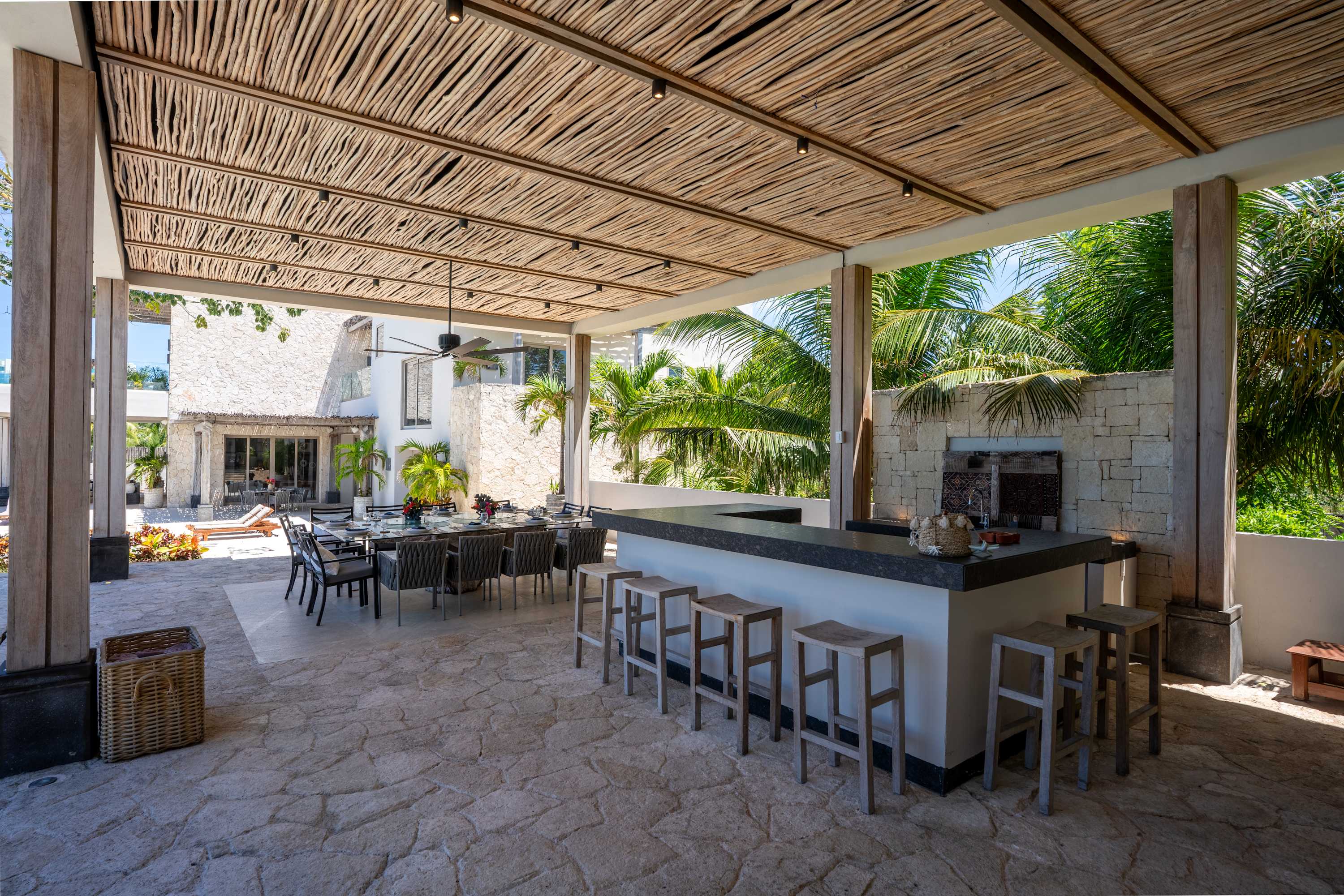 A covered outdoor patio with a bar and dining table.