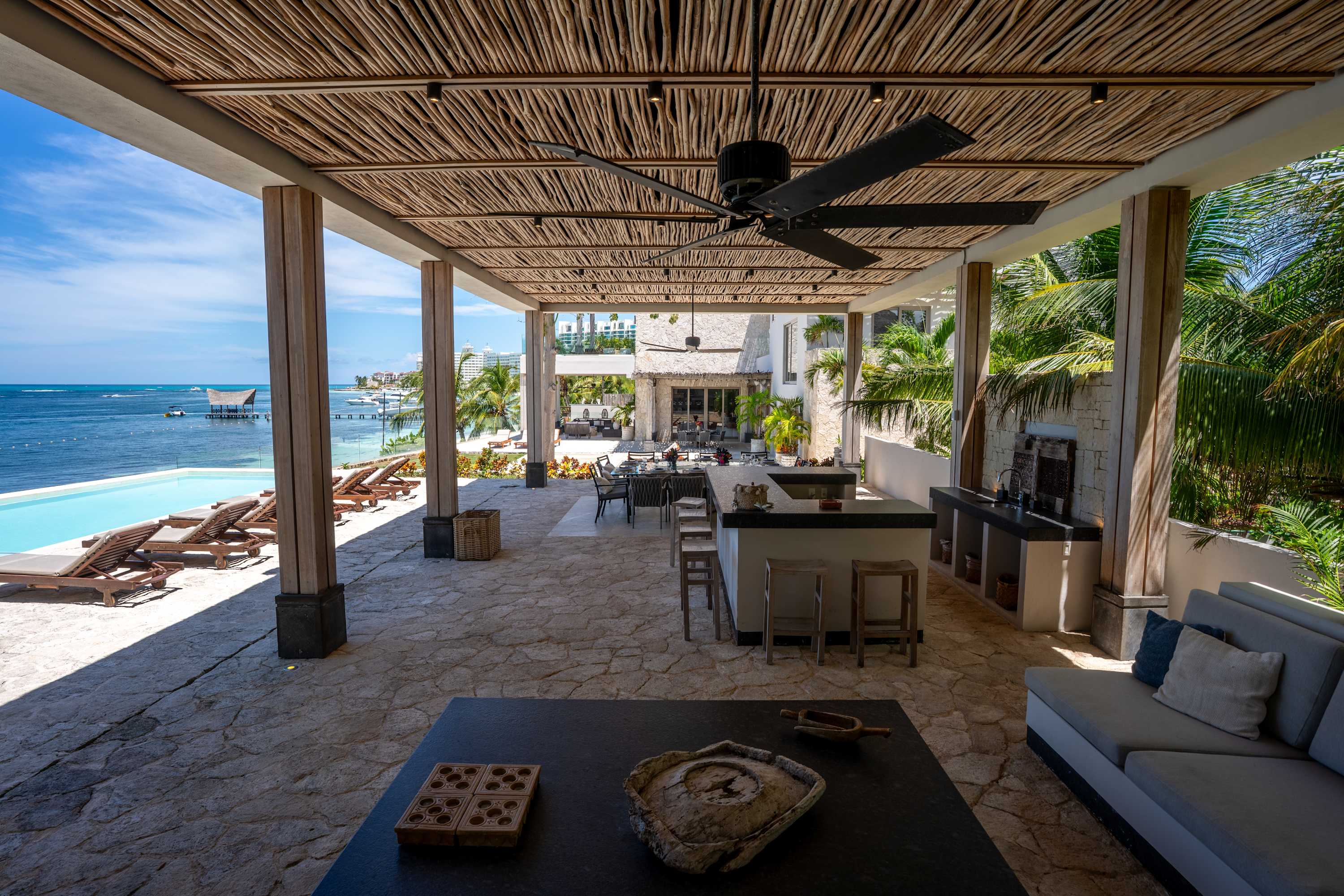 Outdoor patio with a pool, lounge chairs, an outdoor kitchen, and a sectional sofa.