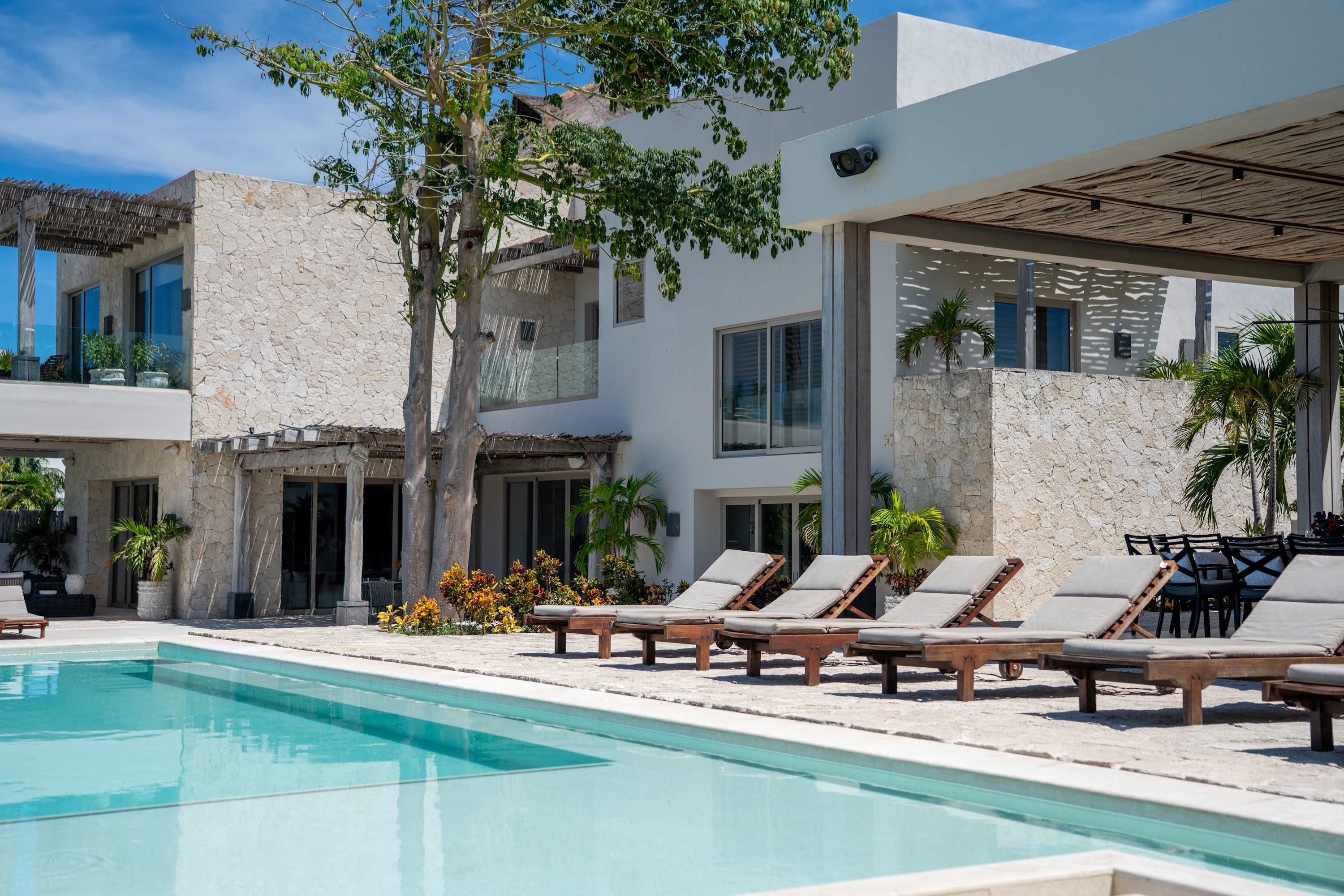 Luxurious resort with a pool, lounge chairs, and modern architecture.