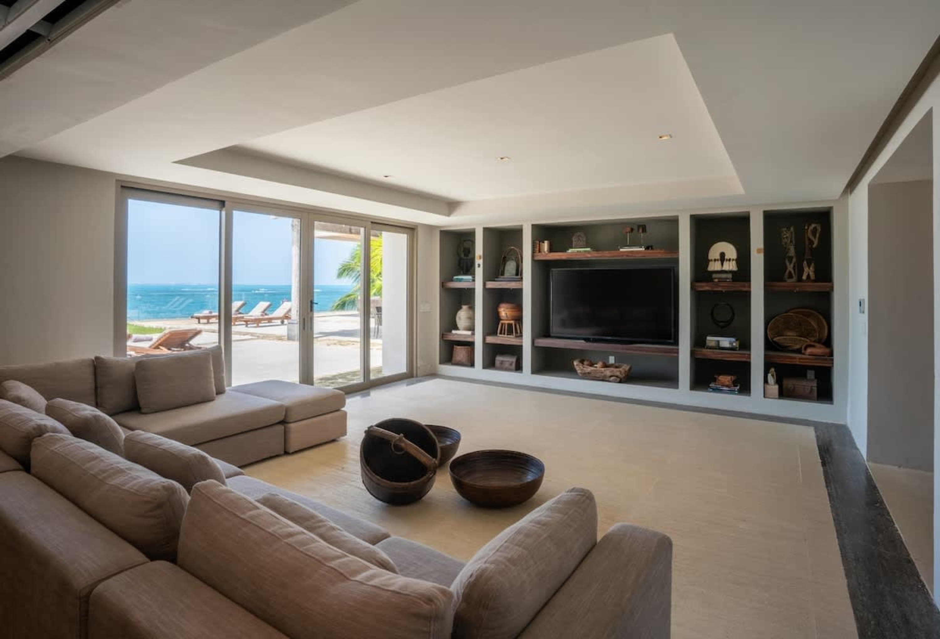 A large living room with a sectional sofa, television, and ocean view.
