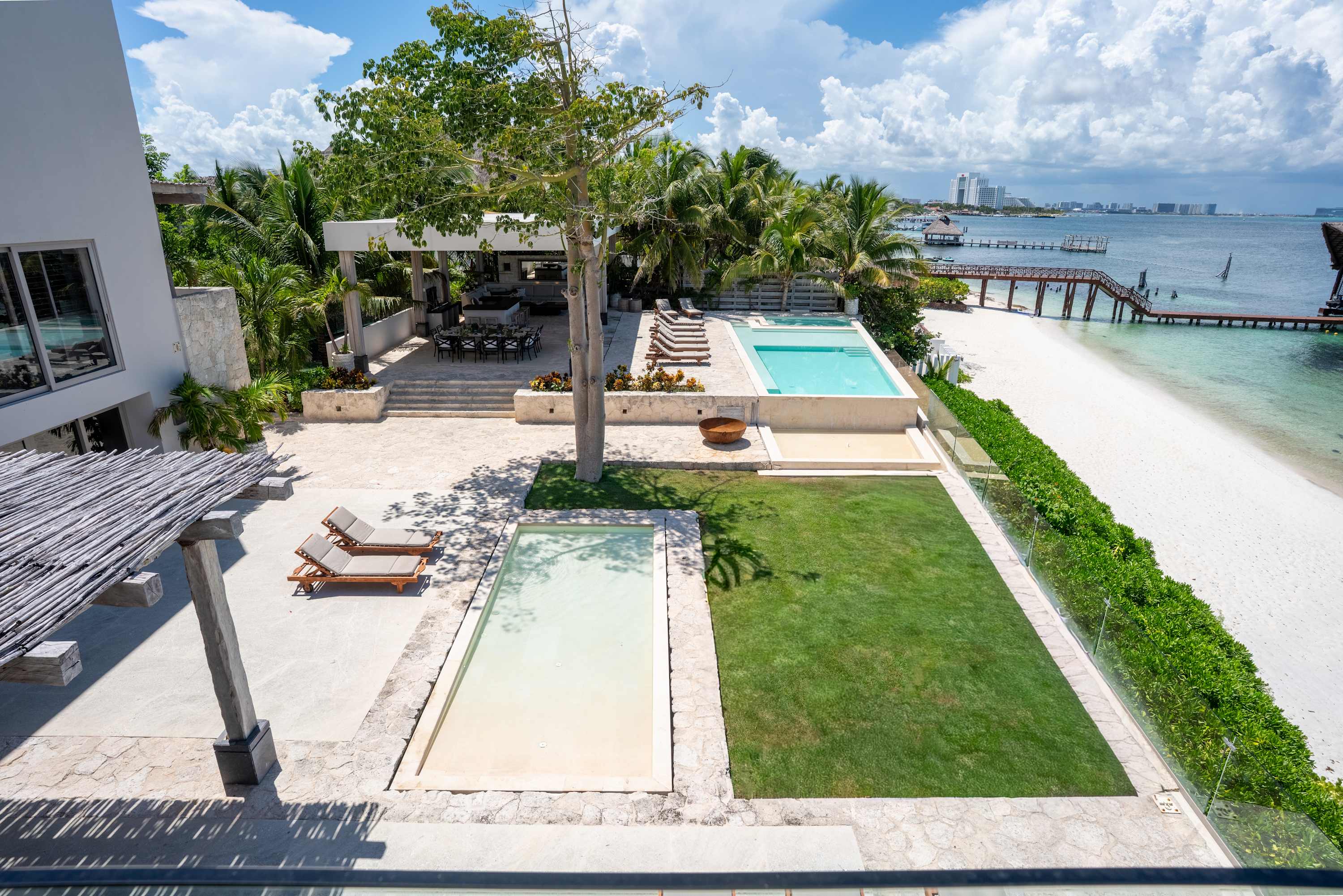 Luxury villa with ocean views, private pools, and a sandy beach.