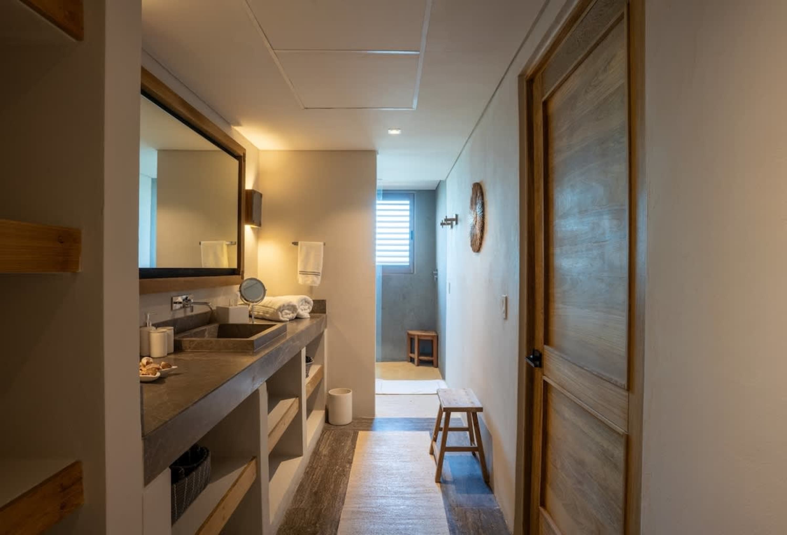 Bathroom with sink, mirror, and wooden door.