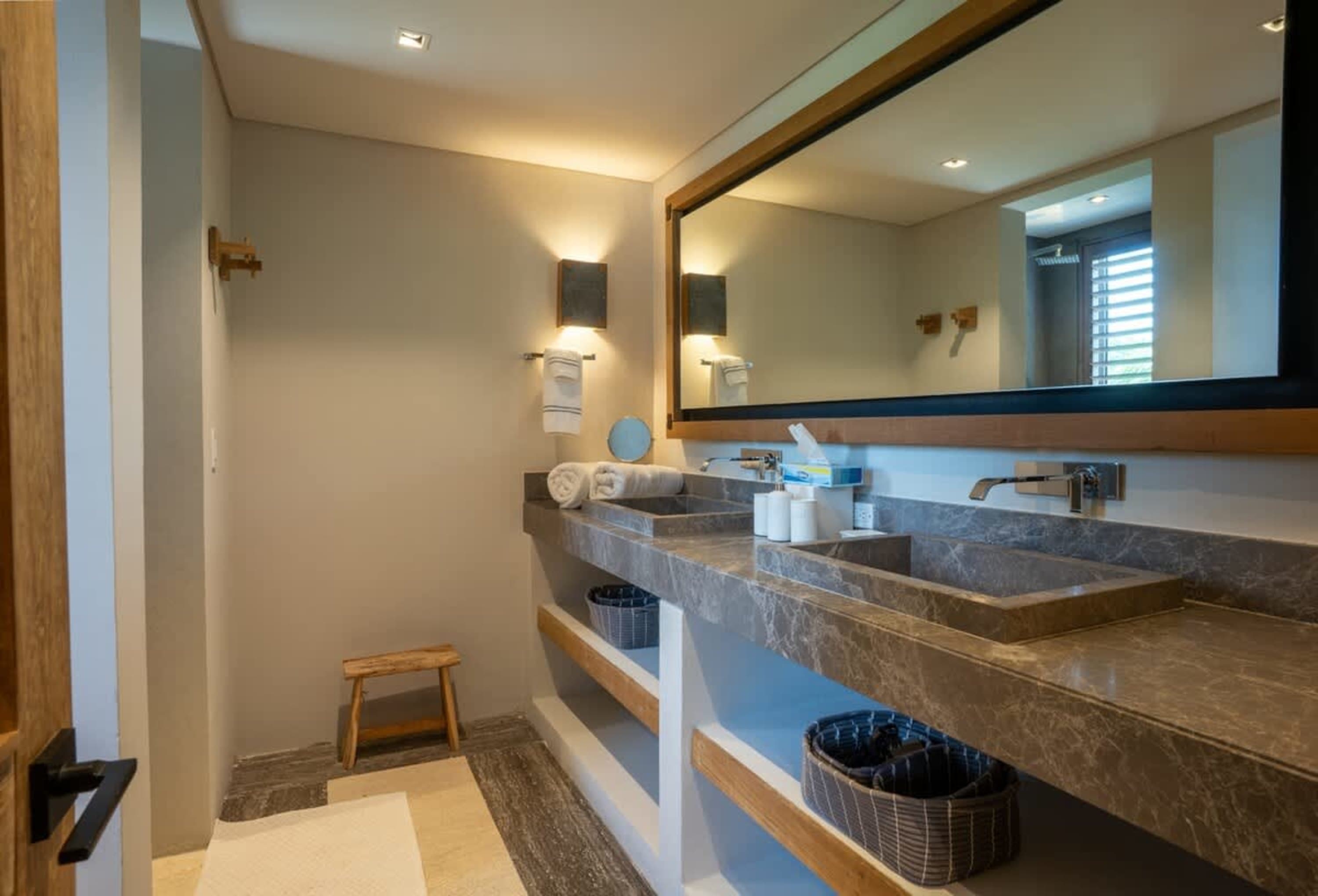 Bathroom with double vanity, marble countertop, and wood accents.