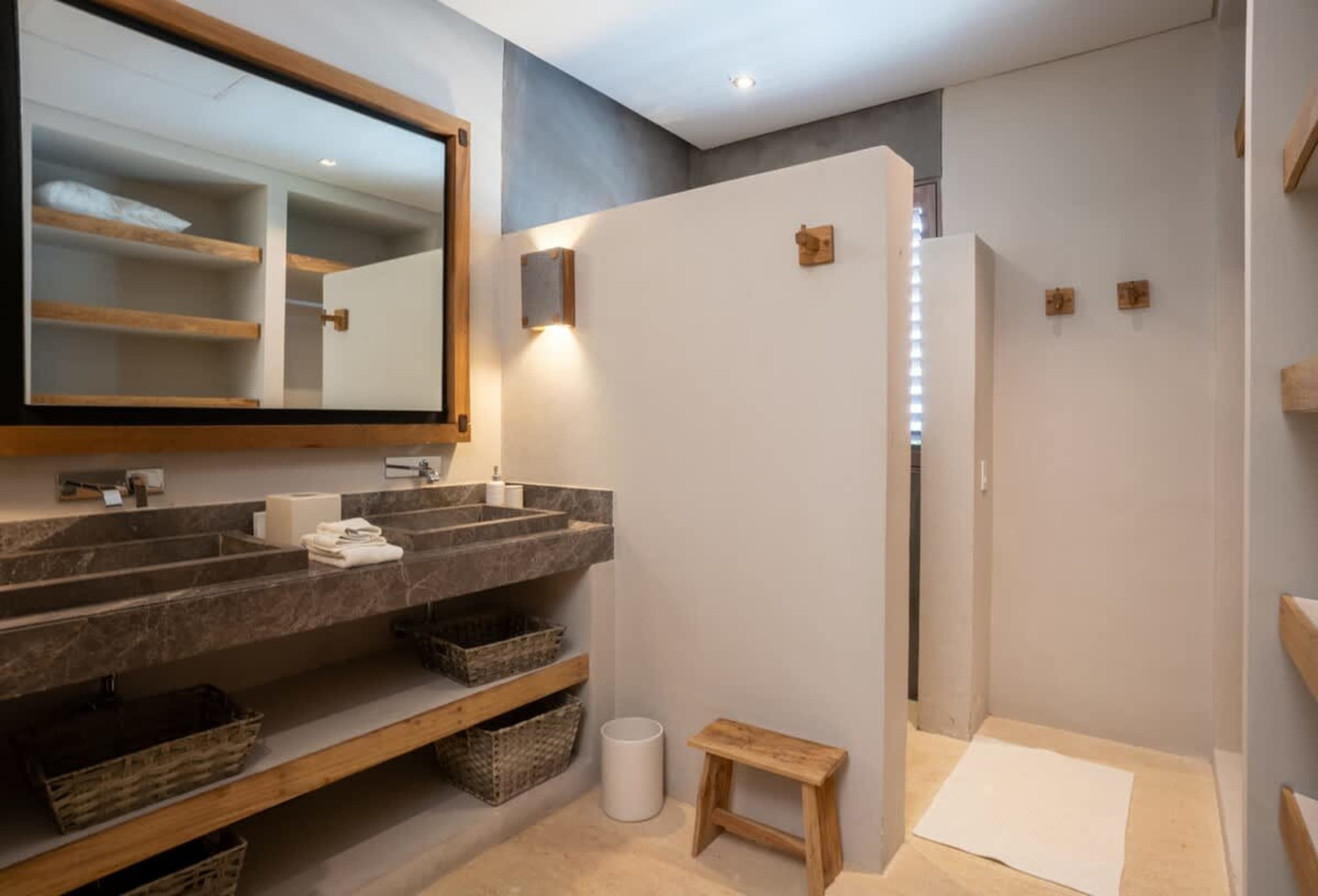 Luxury bathroom with double vanity, walk-in shower, and wooden accents.