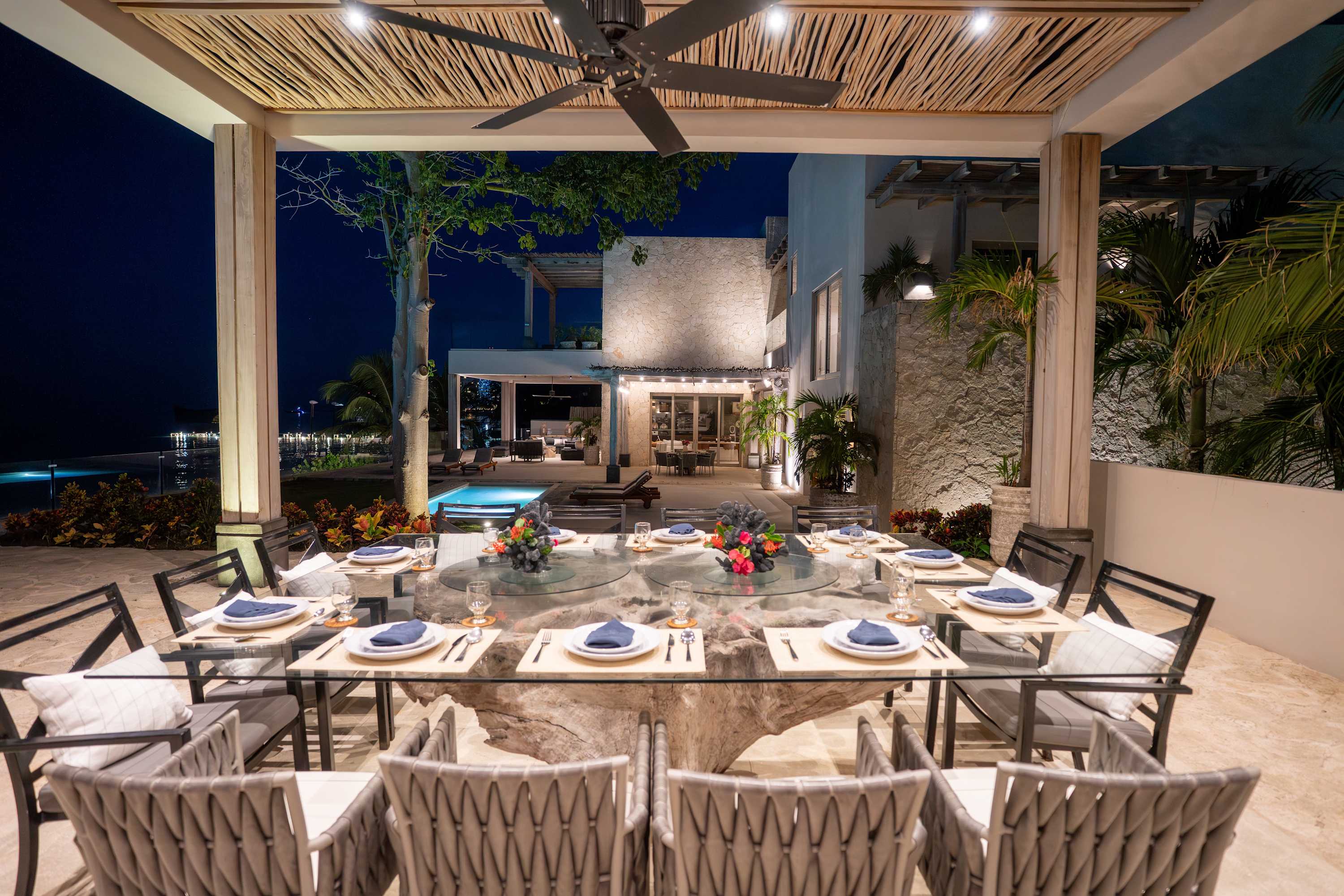 An outdoor dining table is set with plates, napkins, and glasses for a meal.