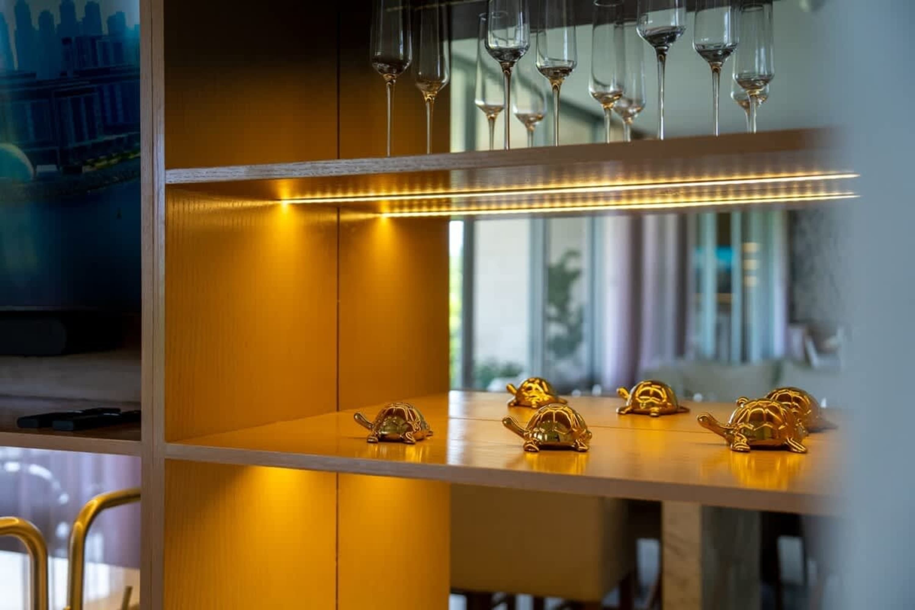 Gold turtle figurines displayed on a lit shelf.
