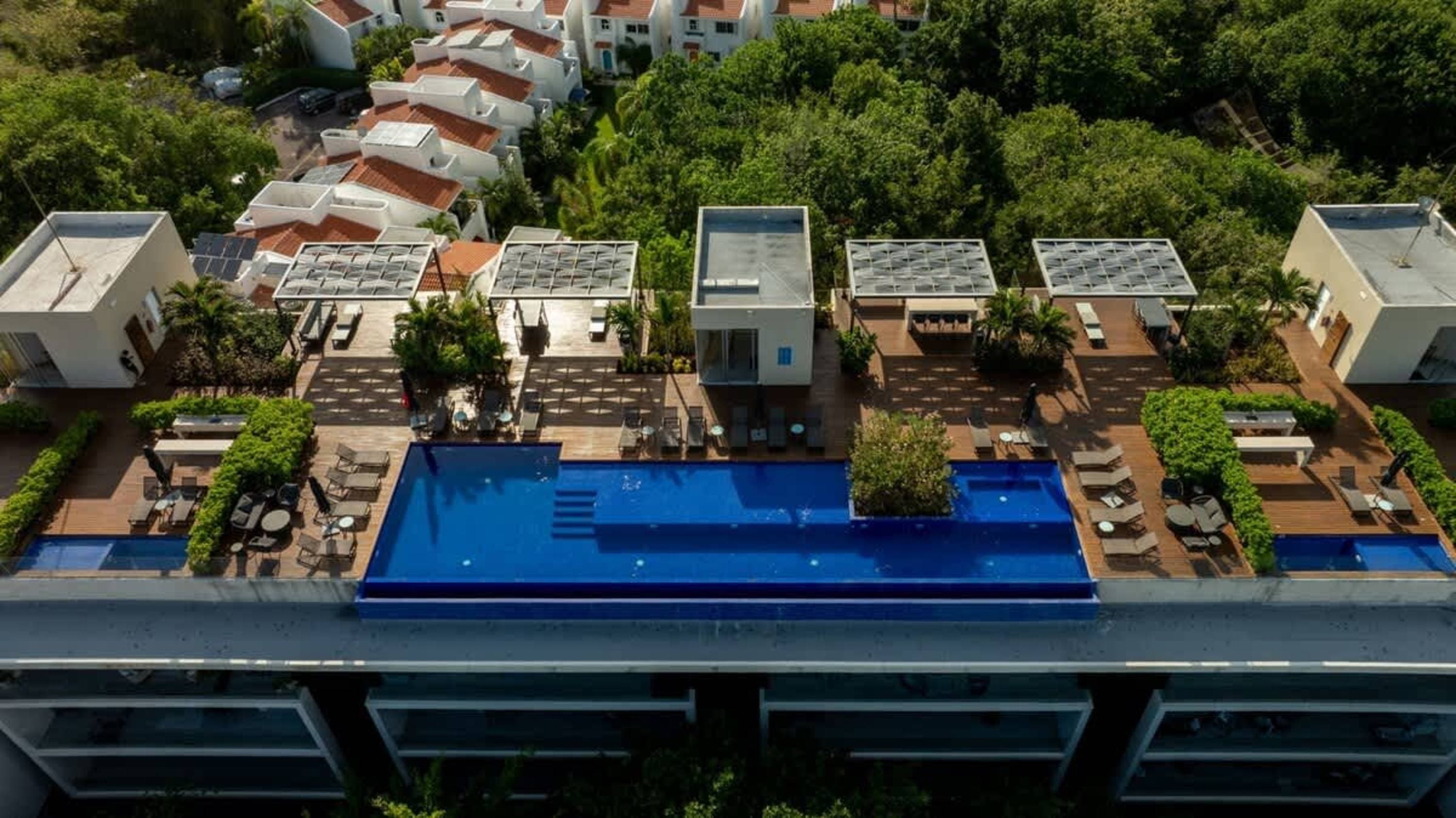 Rooftop swimming pools and lounge areas in a tropical resort setting.