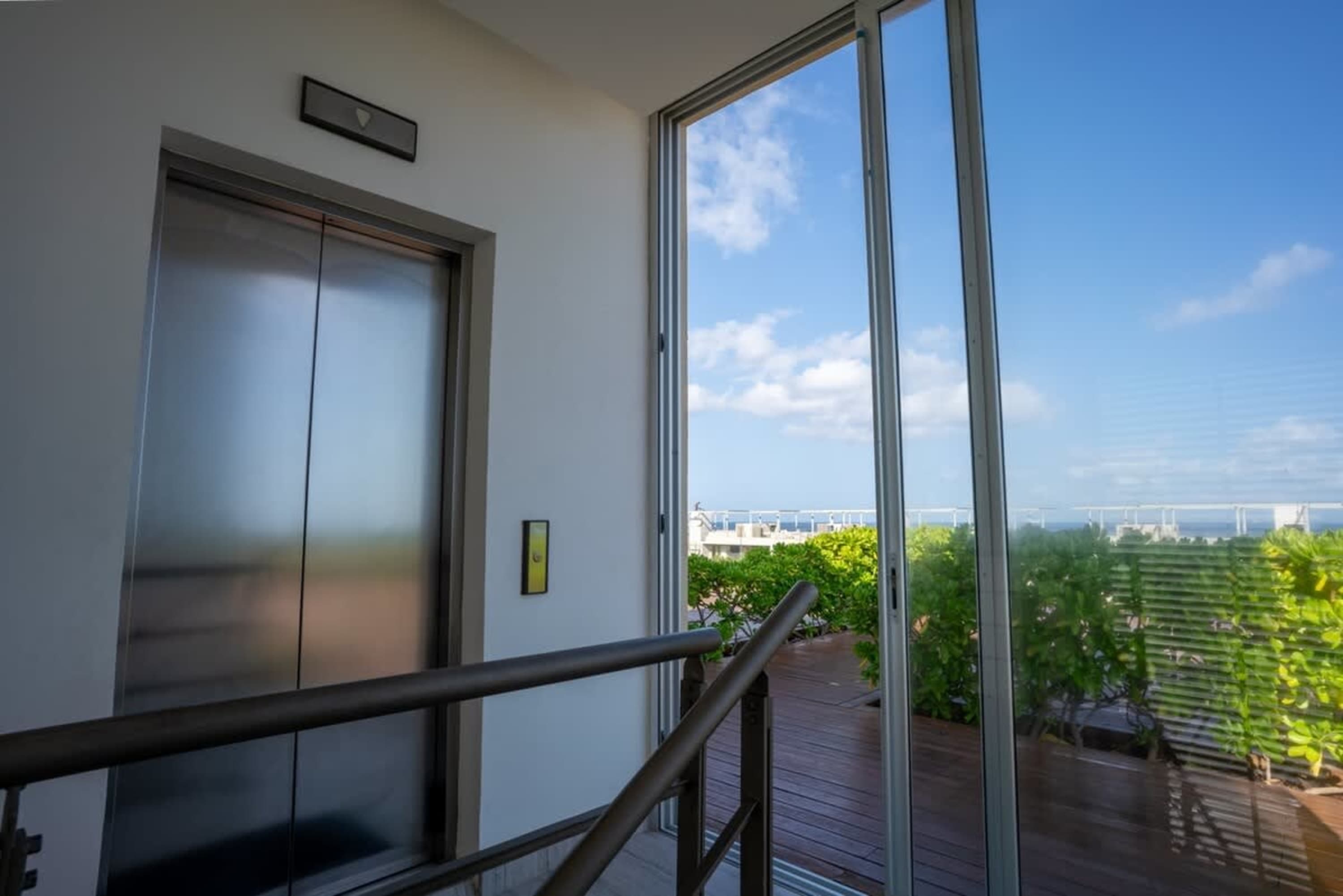 Elevator and stairway leading to a balcony with ocean view.