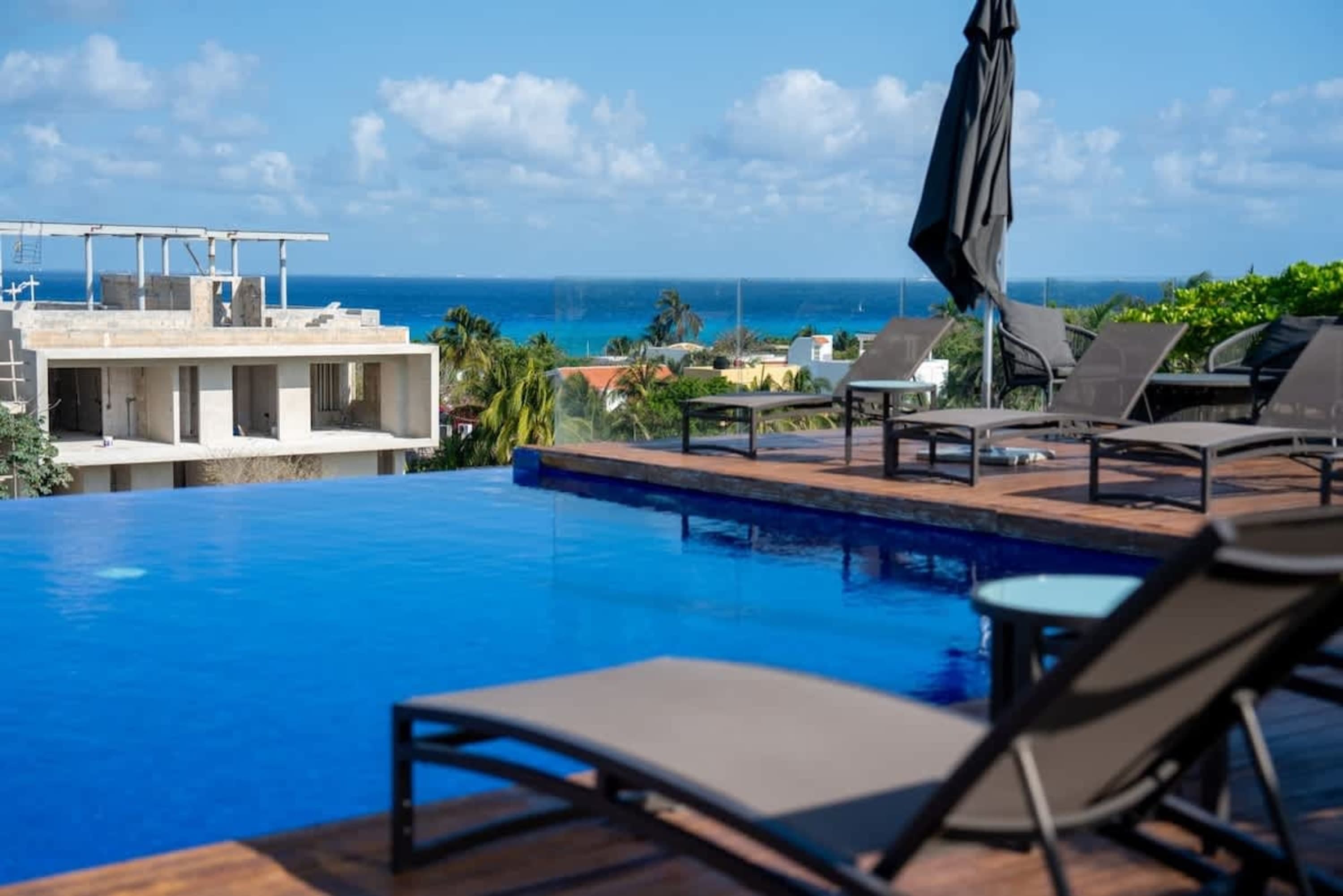 Infinity pool with lounge chairs and a view of the ocean.
