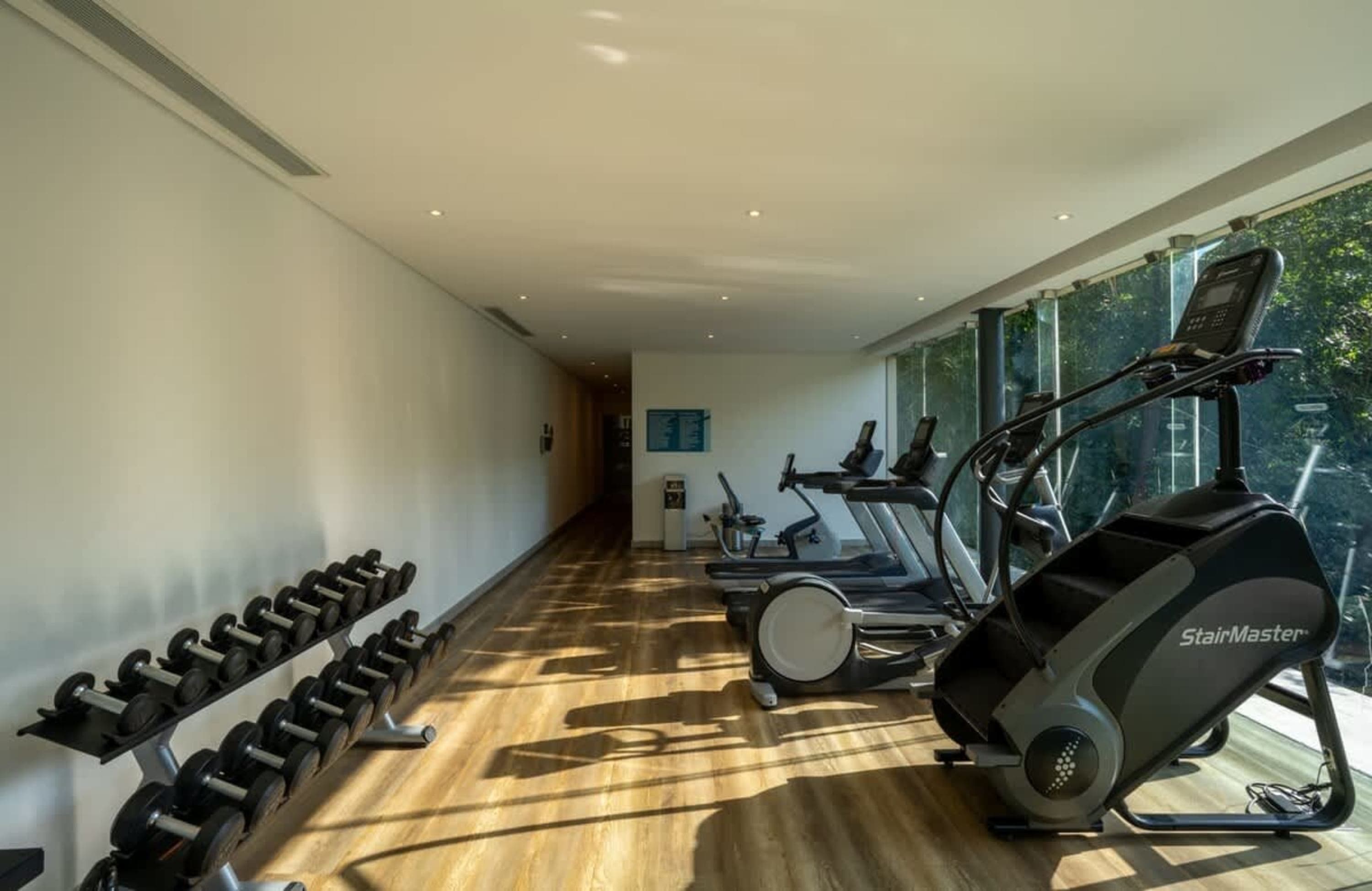 Gym with treadmills, stair climber, and dumbbell rack.