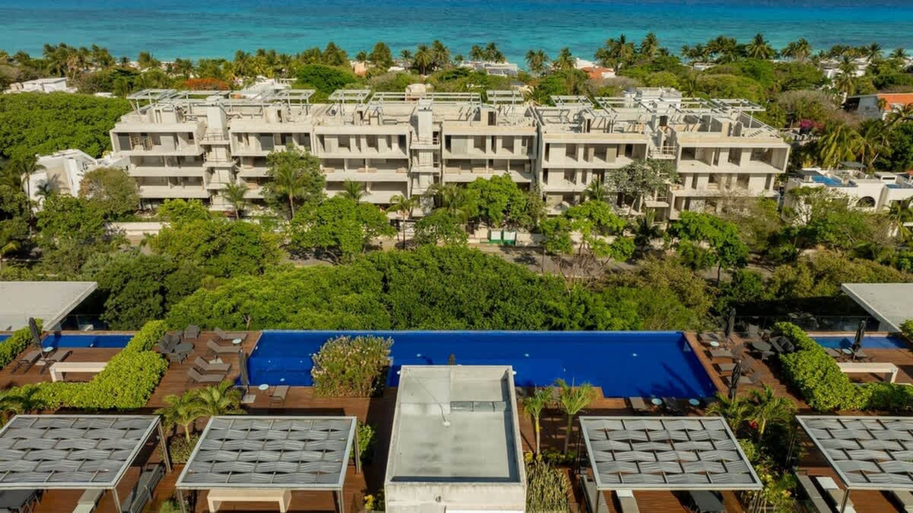 An aerial view of a resort with a pool and ocean.