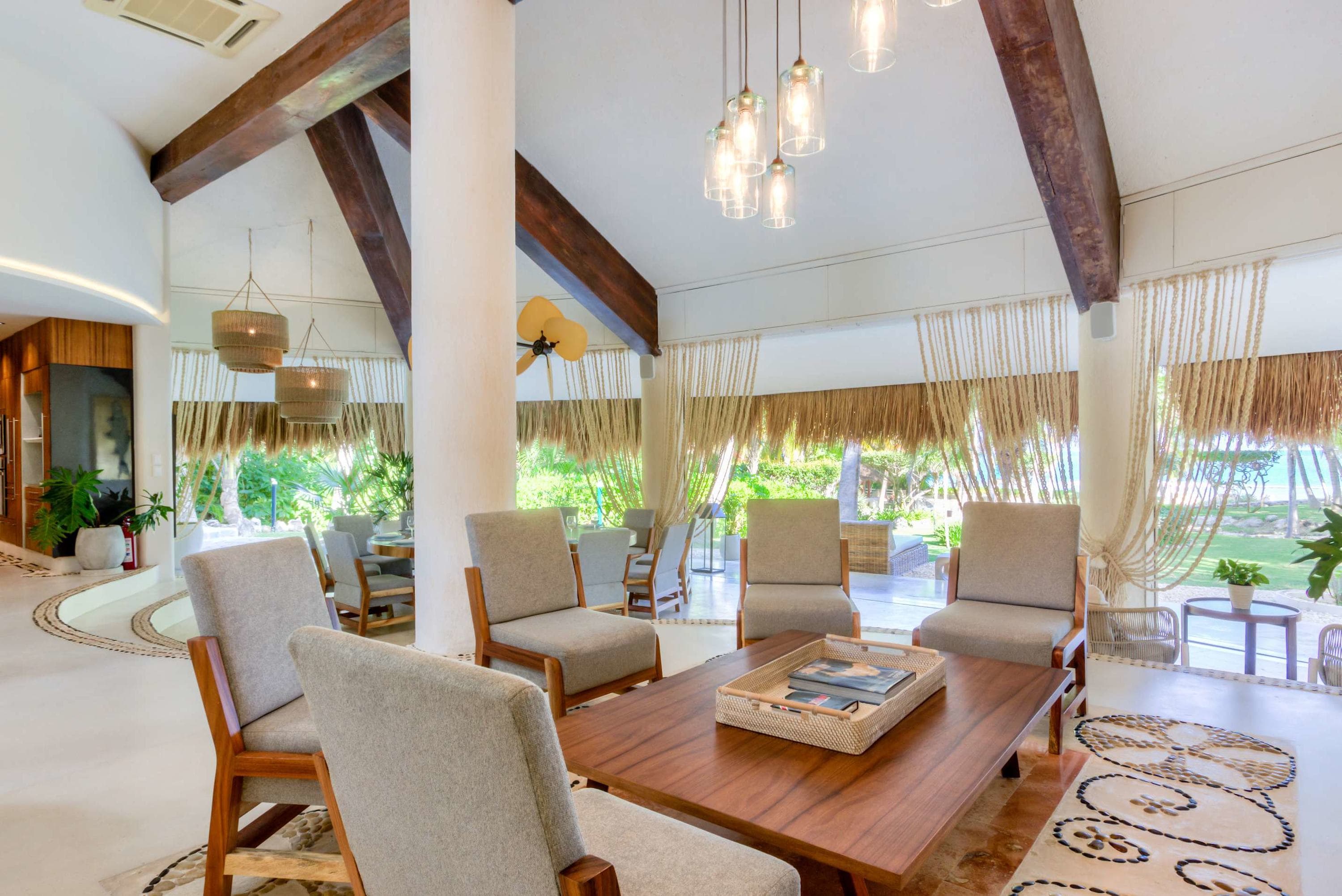 A living room with plush seating, a coffee table, and decorative ceiling beams.
