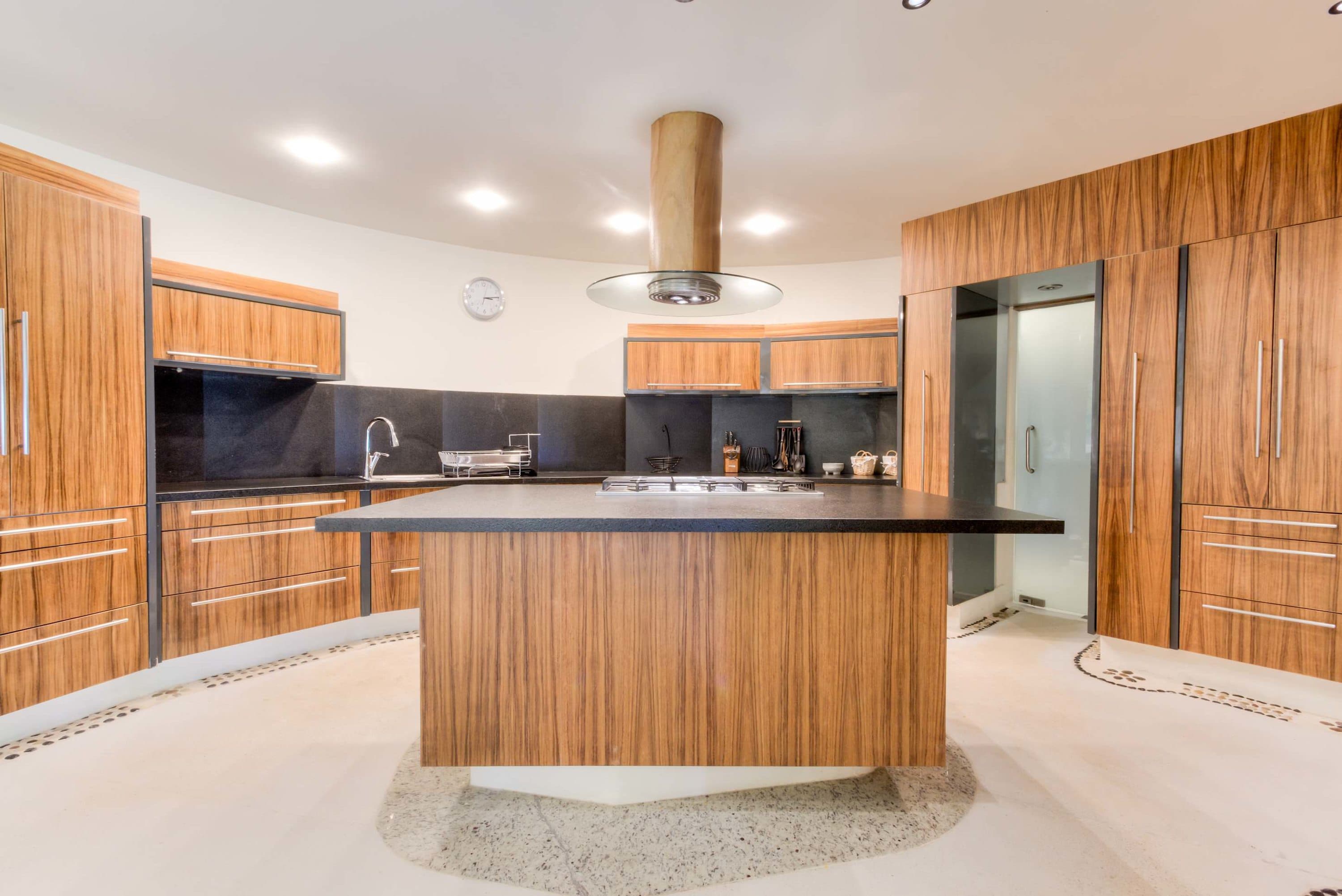 A modern kitchen with wood cabinets and a large island.