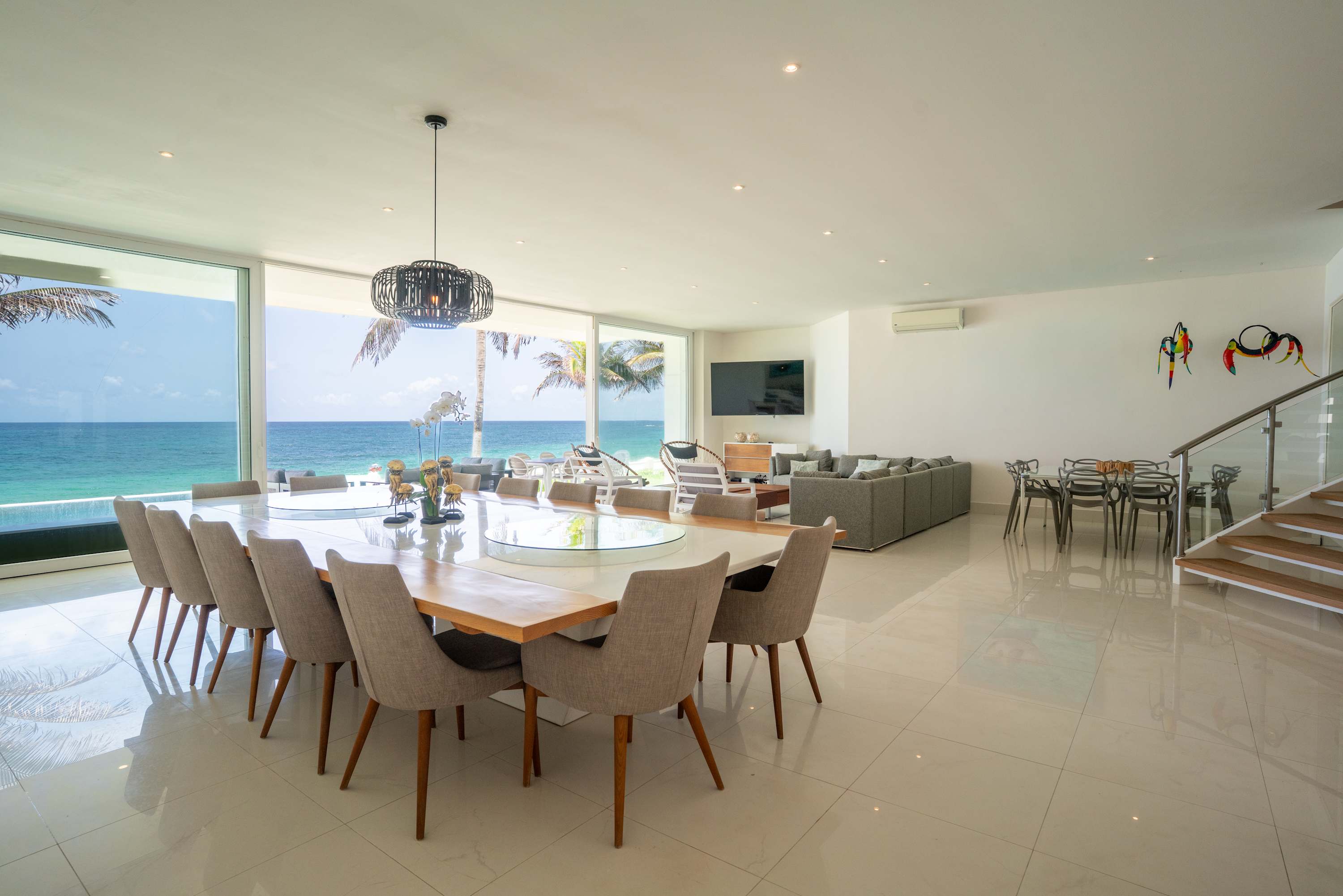 A dining room with a long table overlooking the ocean.
