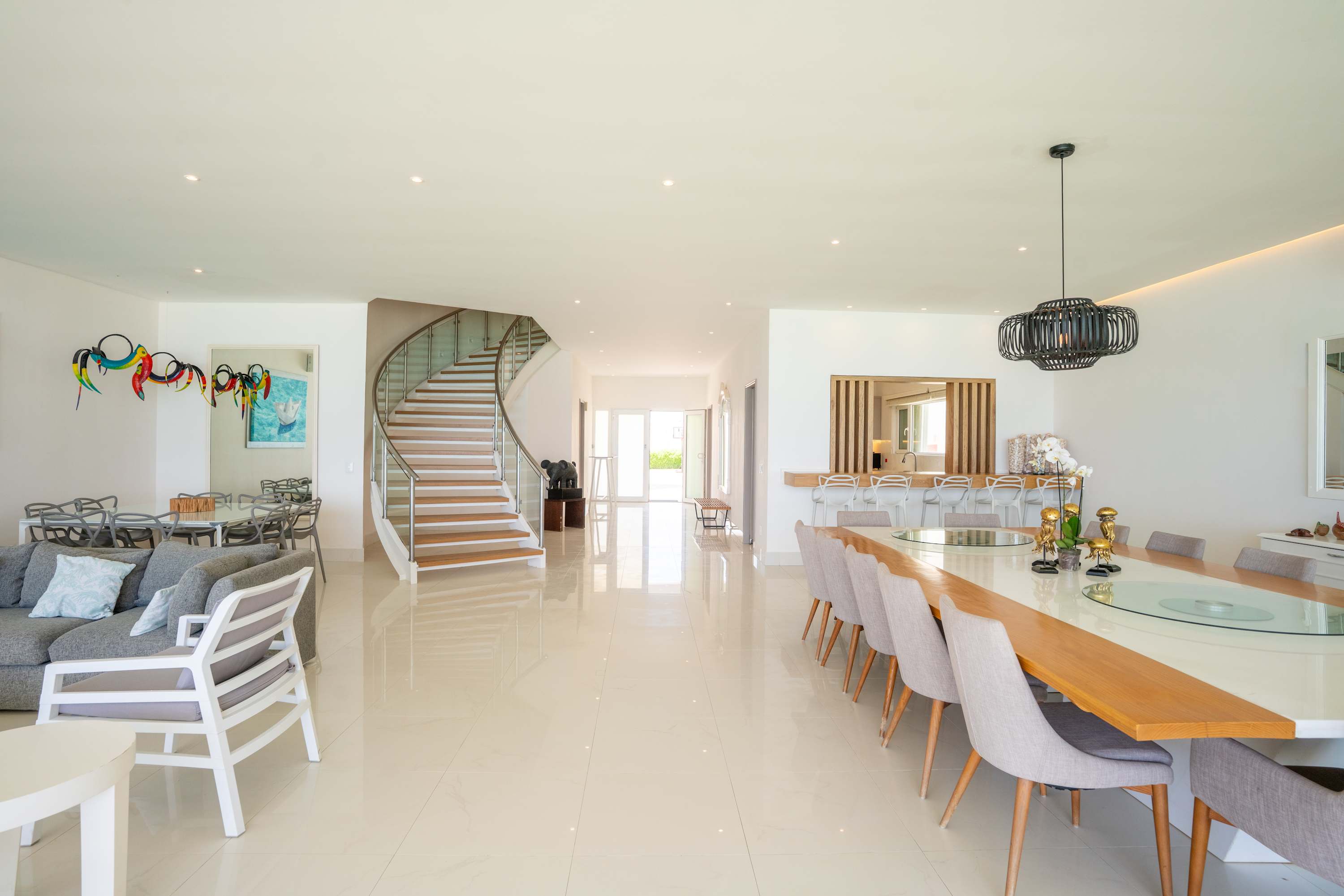 Modern living room with dining area and spiral staircase.