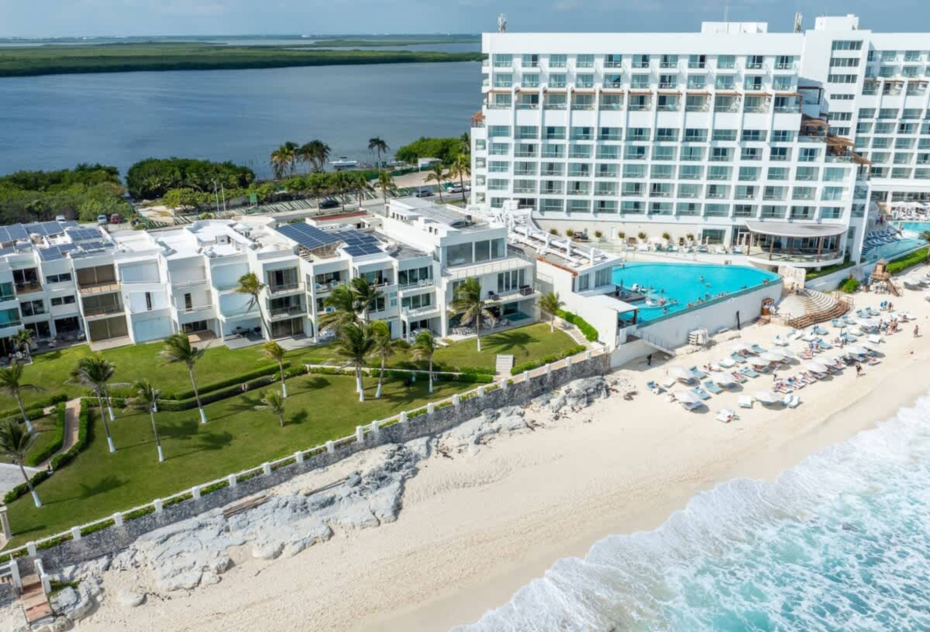 An aerial view of a resort with a large pool and beach.