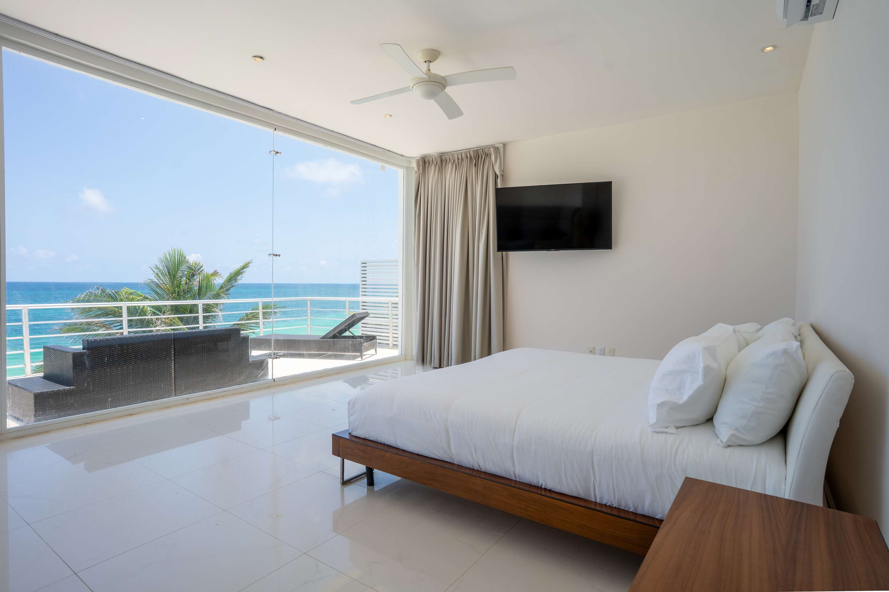 Bedroom with a large window overlooking the ocean.