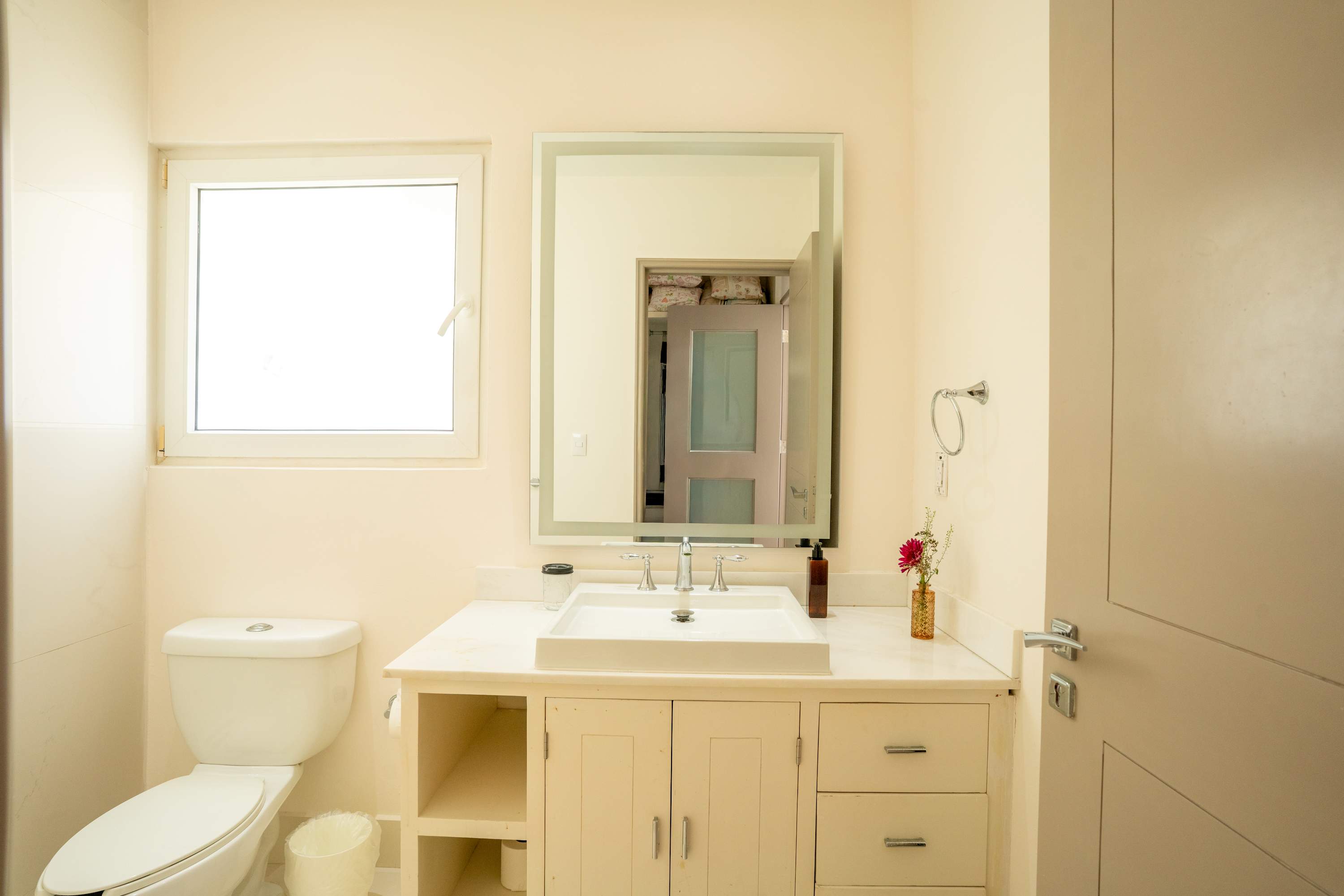 A bright, clean bathroom with a white toilet and sink vanity.