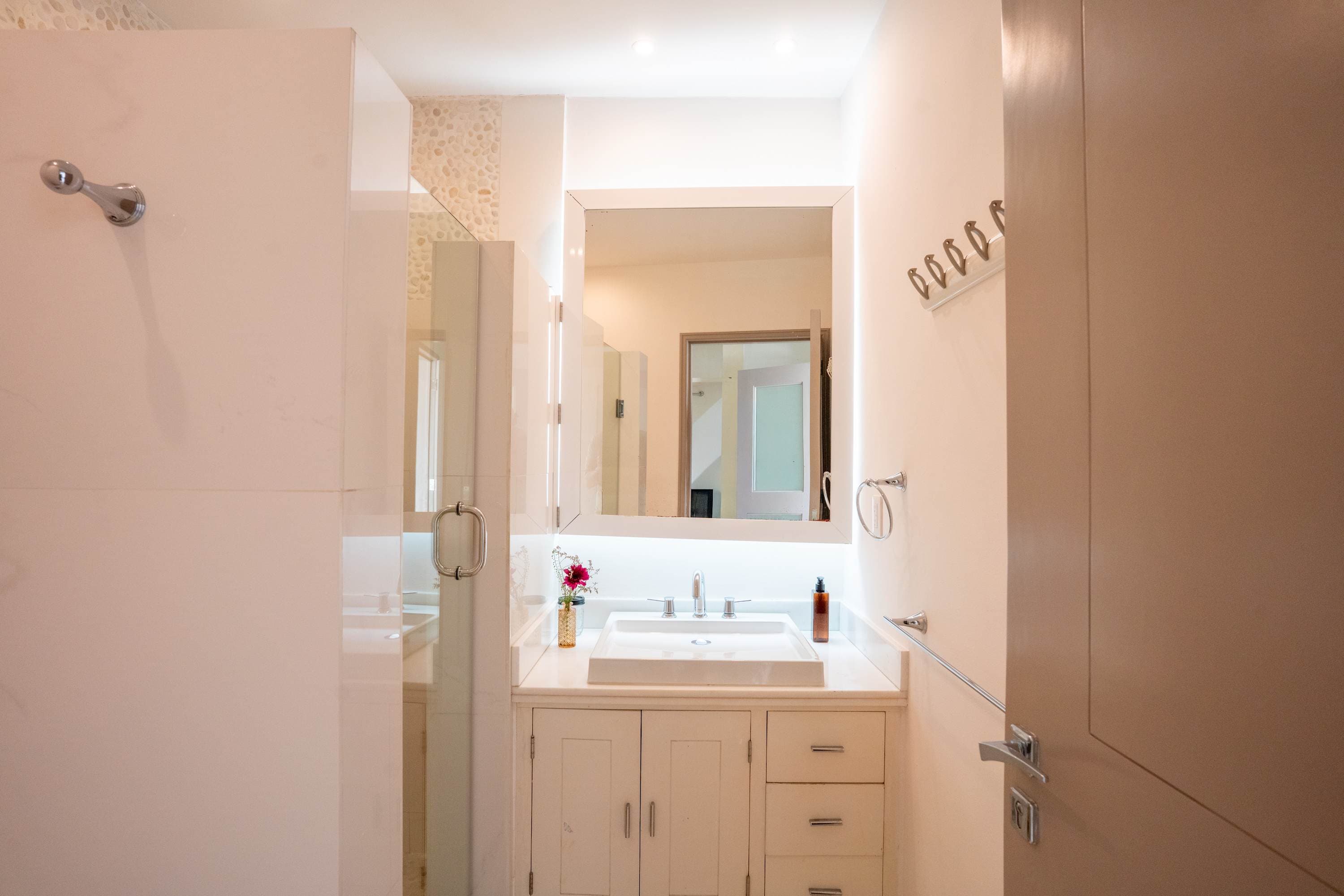 A modern bathroom with a white sink and vanity.