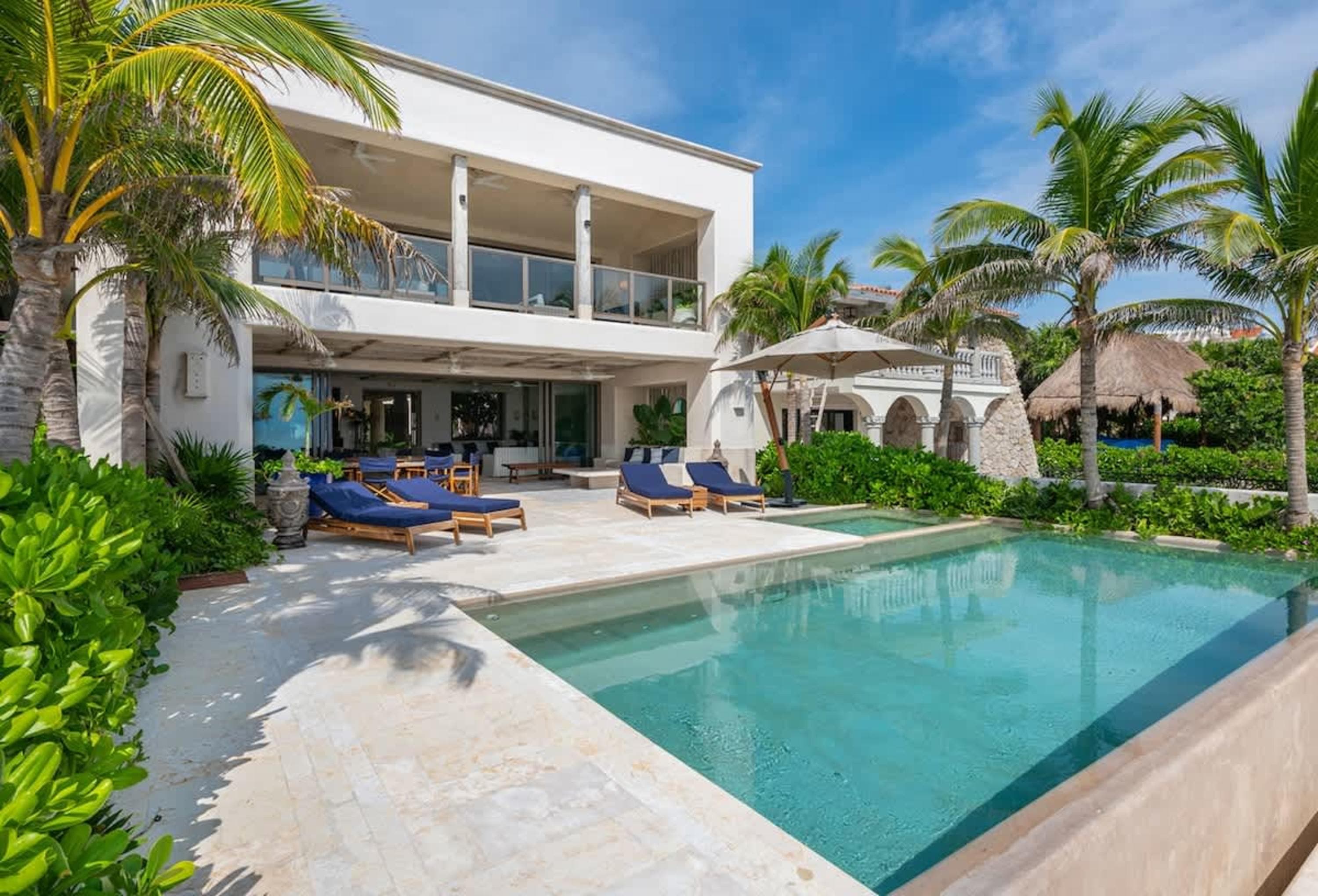 A luxurious villa with a swimming pool and palm trees.