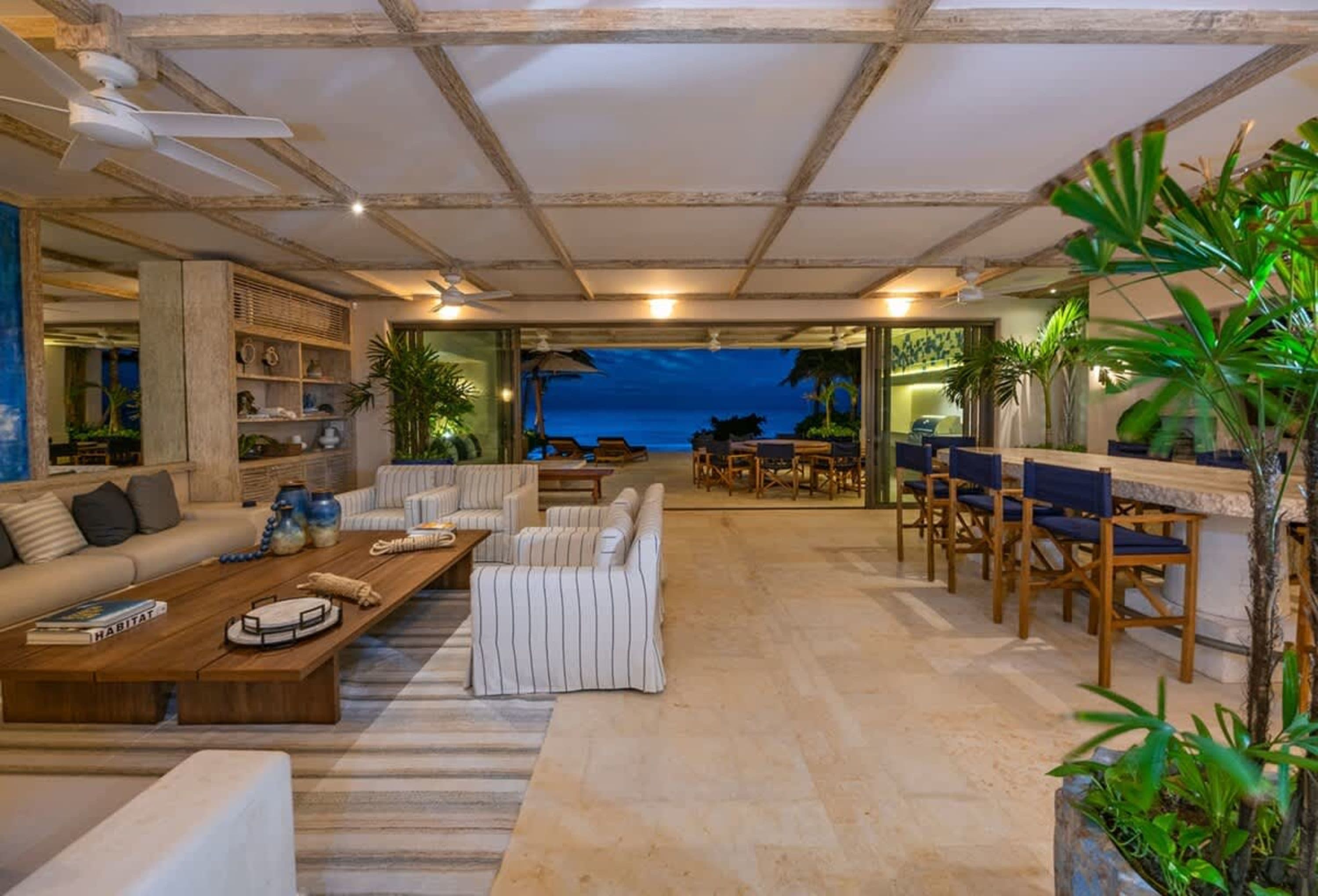Living room with view of the ocean at dusk.