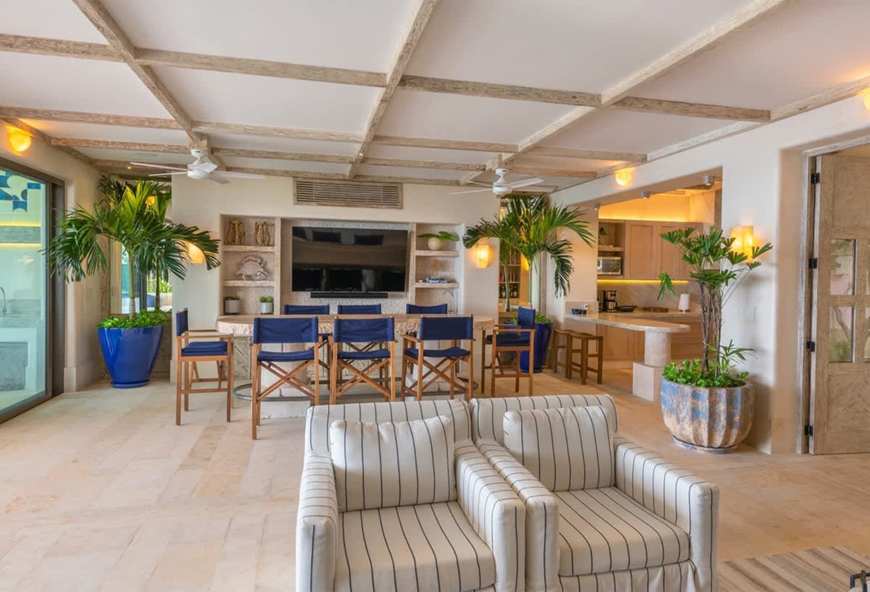This is a luxurious and spacious living and dining area with a modern tropical theme.