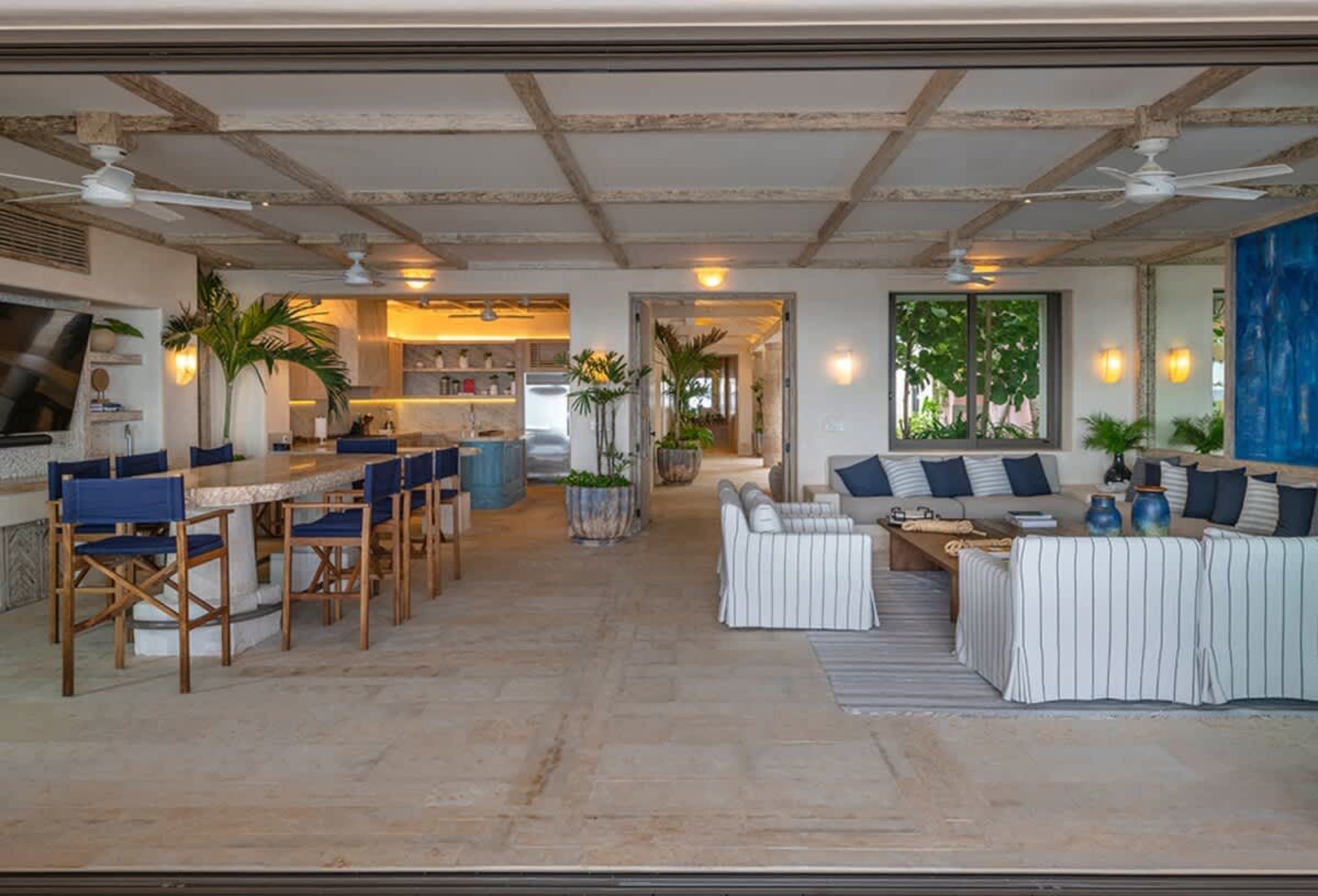 An open-plan living and dining area with a kitchen in the background.