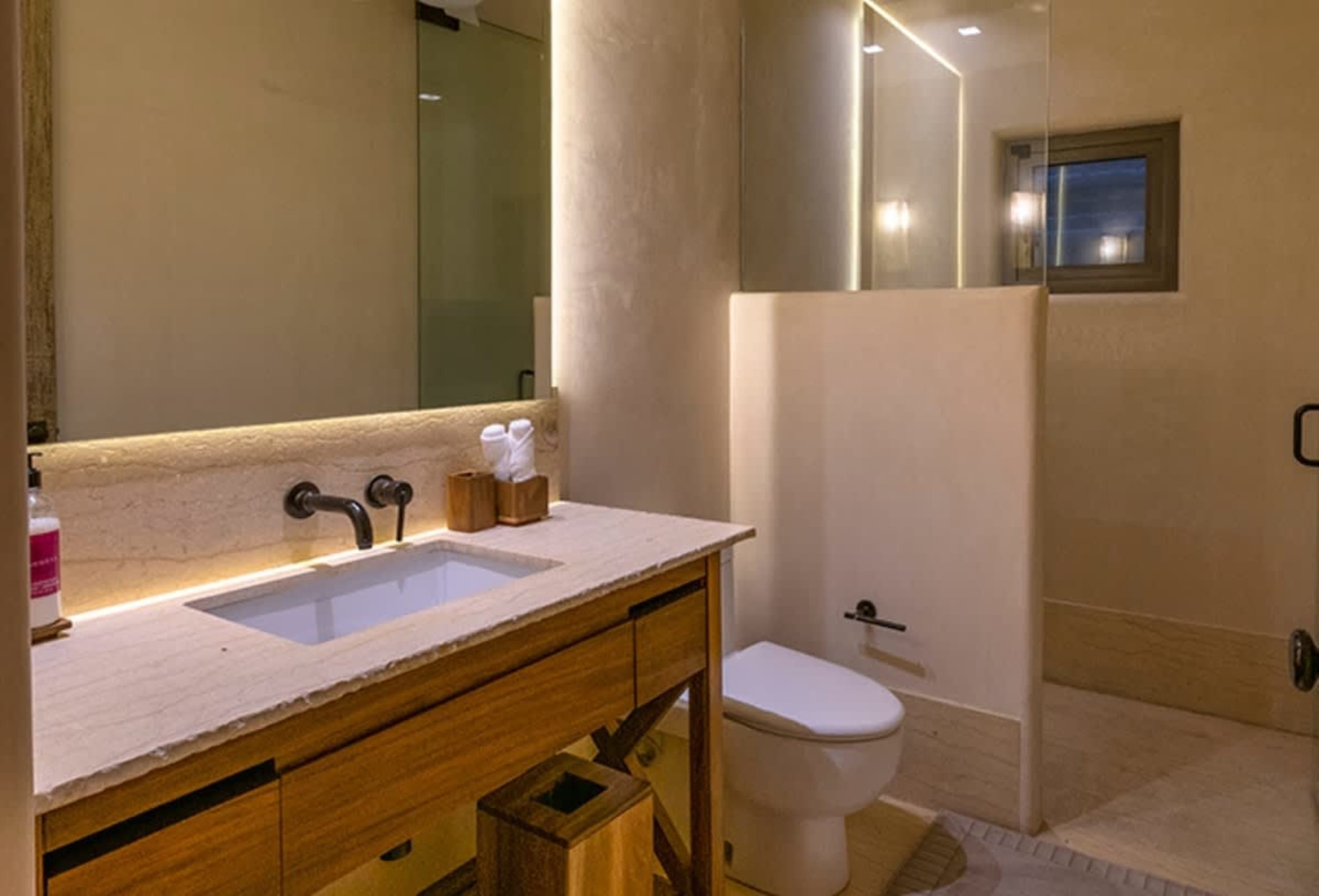 A modern bathroom with a sink, toilet, and shower.