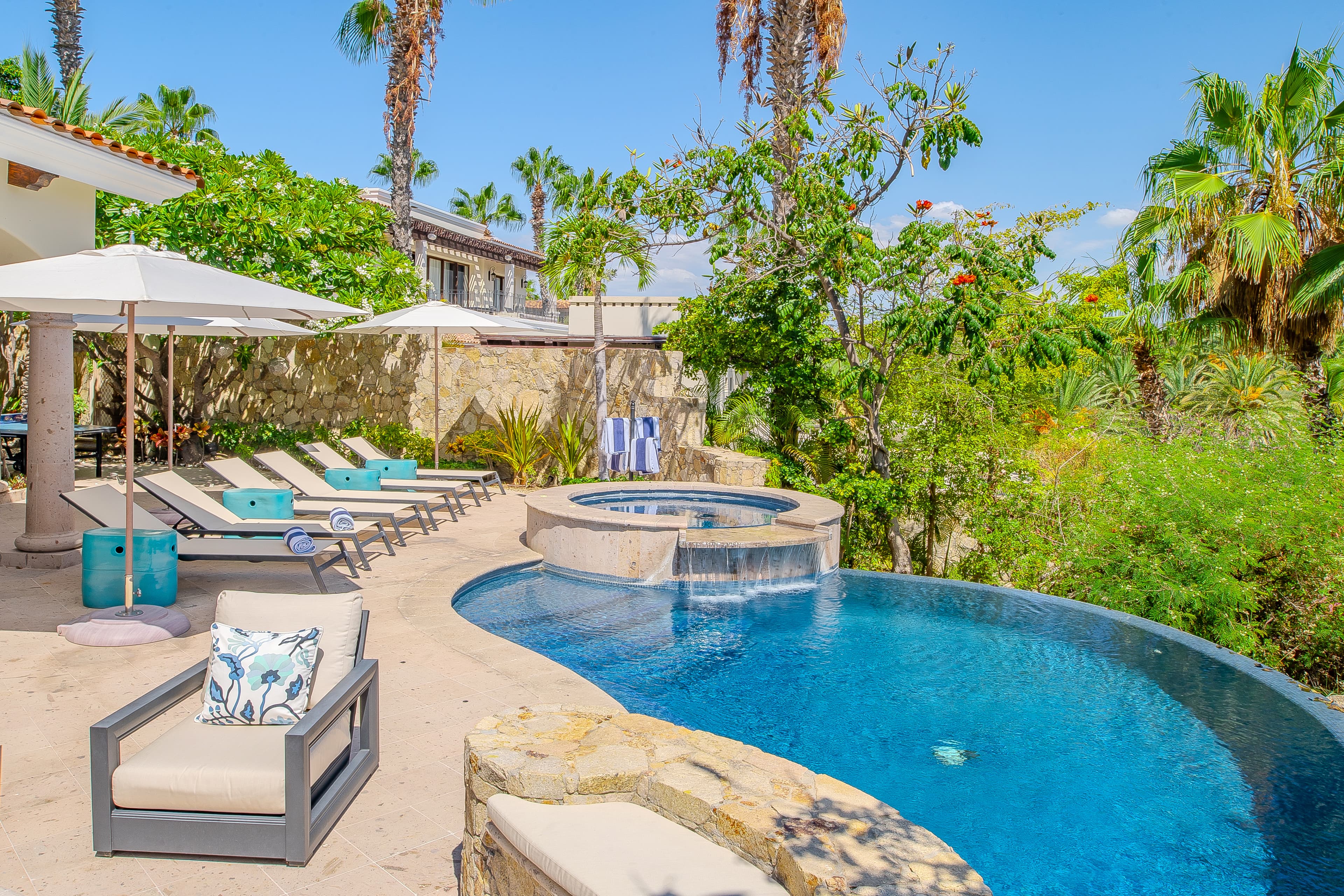 Private pool and spa surrounded by lush tropical gardens, with lounge chairs and shaded seating inviting your perfect afternoon of relaxation in the sun.