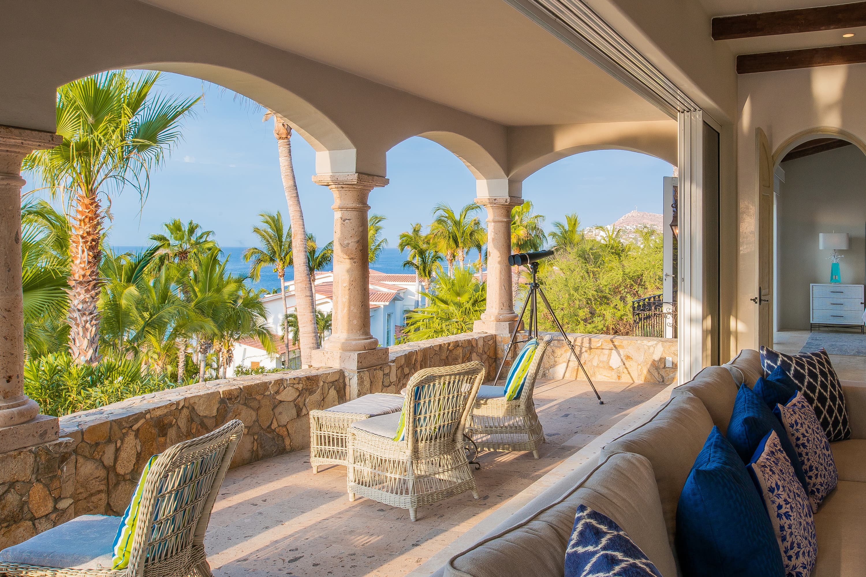 One of the patios of this Los Cabos Luxury Vacation Villa, with a telescope and patio chairs.