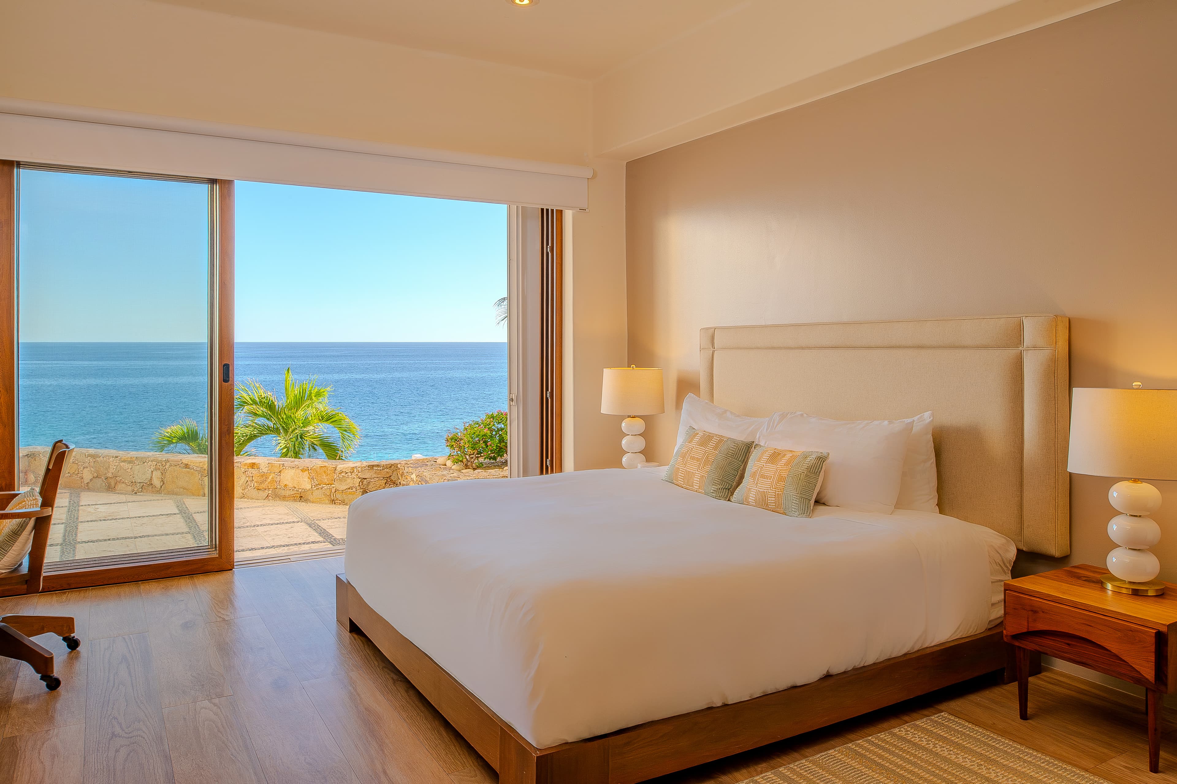 Bedroom 4 · Wake up to breathtaking ocean views from your serene bedroom, where floor-to-ceiling windows frame the endless blue horizon and tropical palms sway just beyond your private terrace.