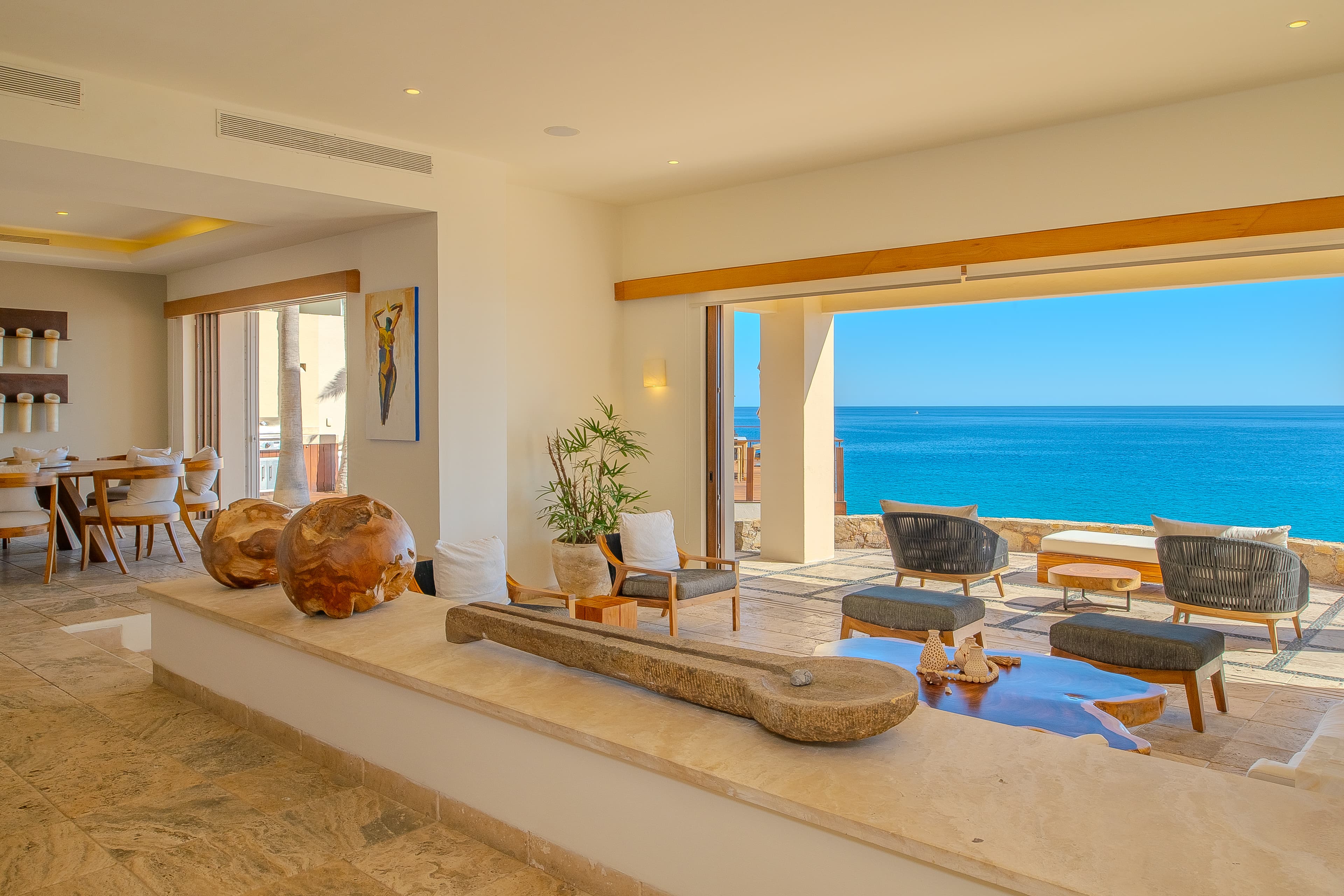 Sunlight streams through your living space, framing stunning ocean views that stretch endlessly beyond the terrace. Natural textures and warm woods create an inviting sanctuary where relaxation feels effortless.
