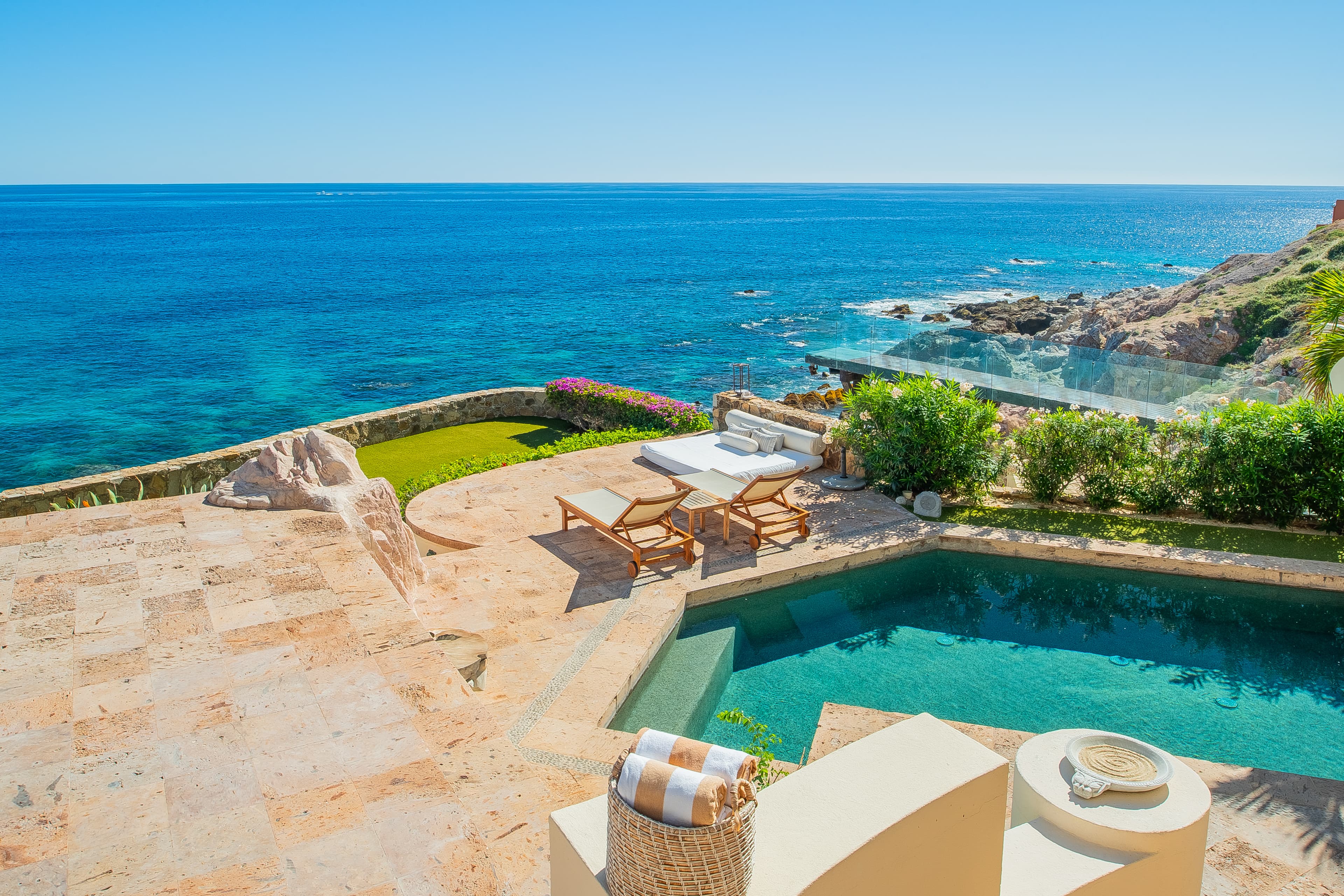 Picture yourself lounging by your private pool with breathtaking turquoise waters and coastal cliffs as your backdrop—your ultimate oceanfront escape awaits.