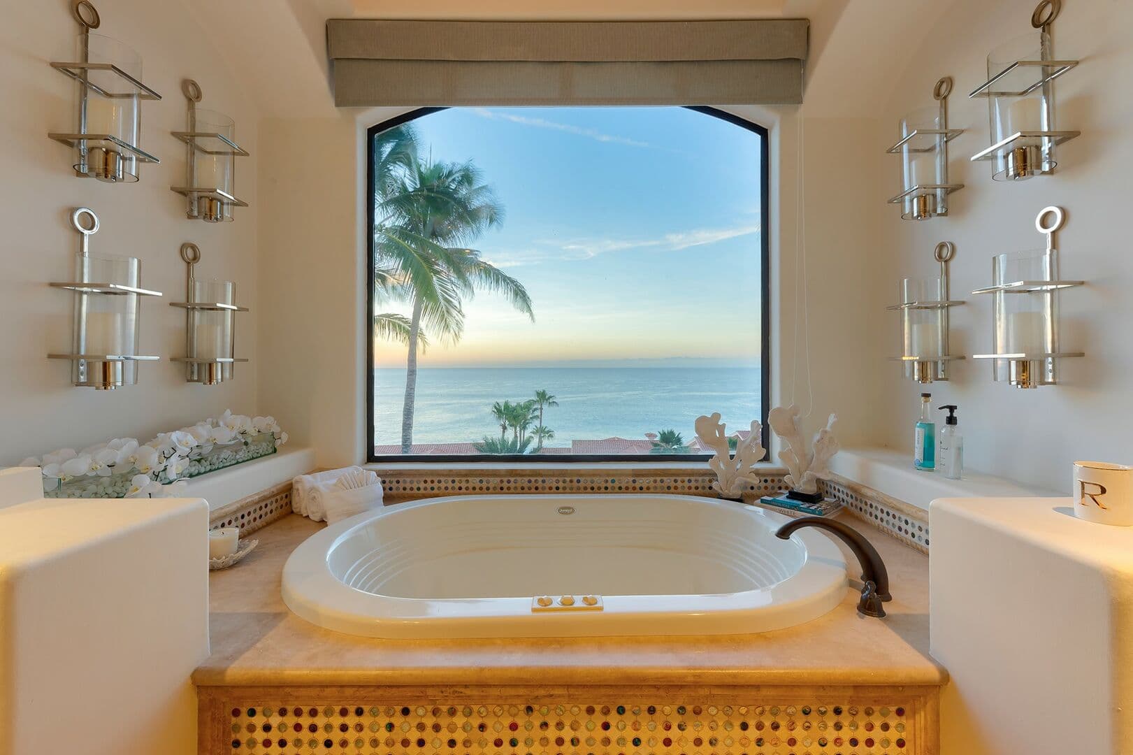 A large bathtub in the master bathroom view a big window showing the ocean.
