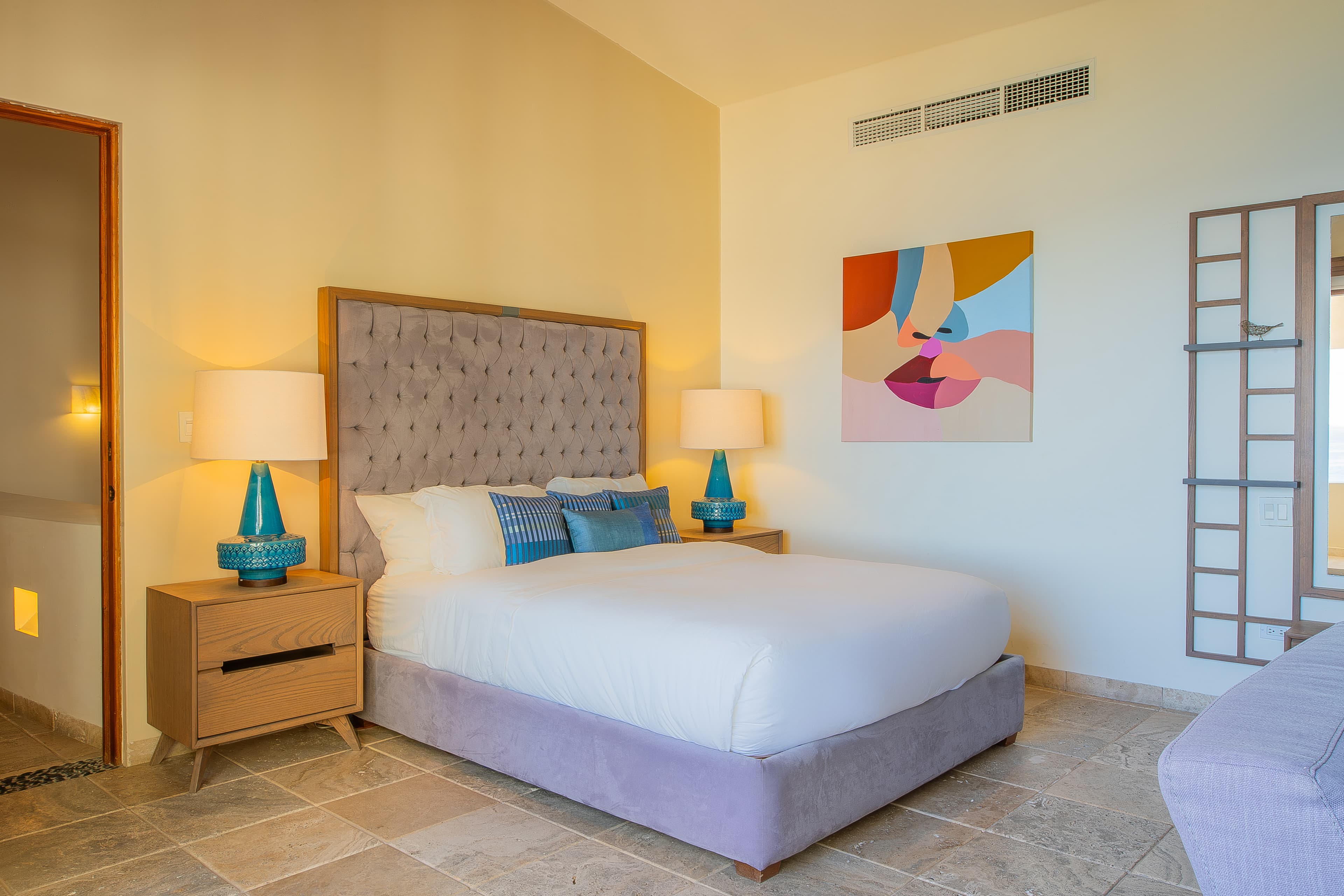 Bedroom 3 · Sink into plush linens and vibrant artwork in your serene bedroom, where soft lighting and thoughtful design invite you to truly relax.