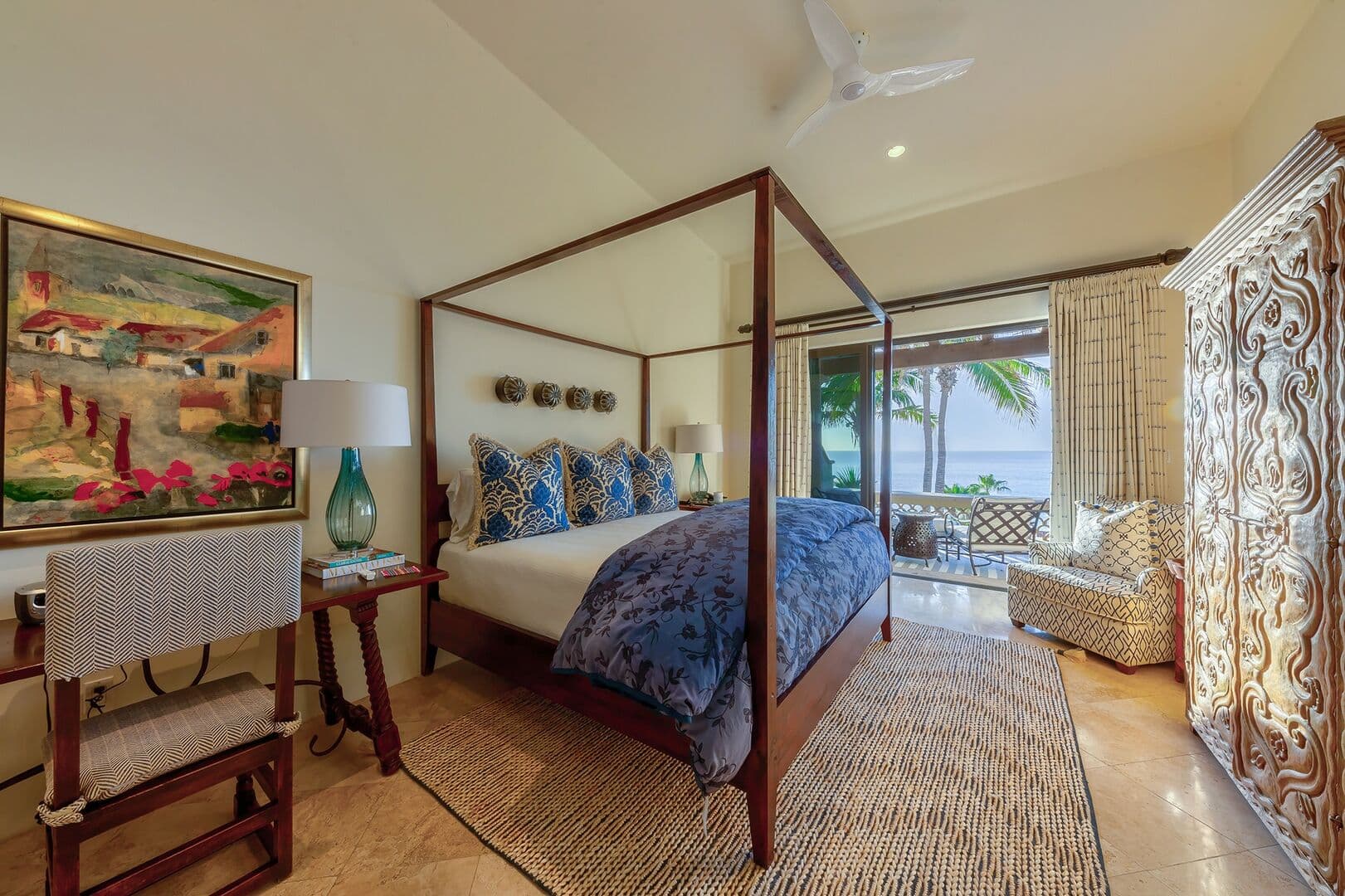 Bedroom one of Pura Vida with a solid wood bedframe and view of the ocean from the balcony.