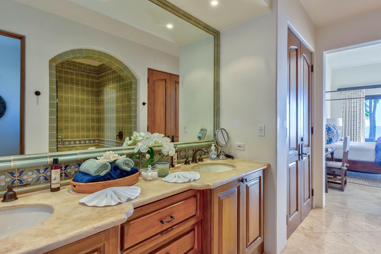 View of the double vanity and bedroom from the shower entrance.