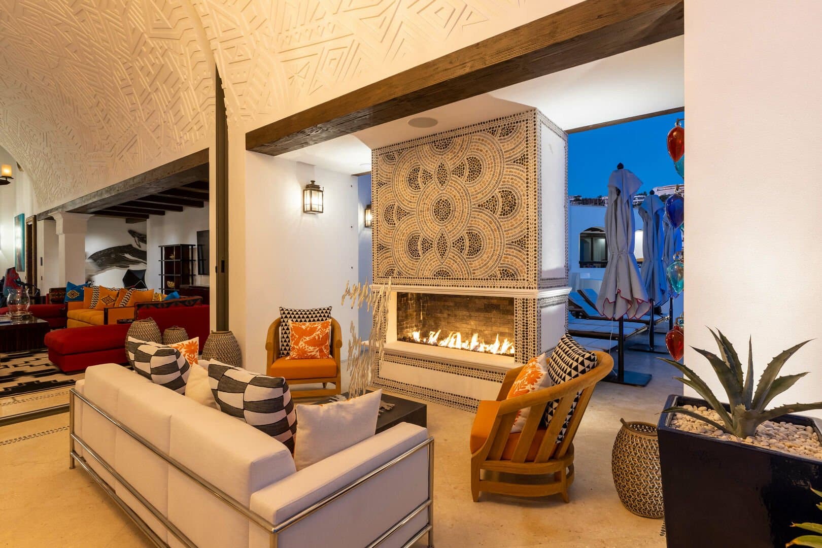 A fireplace in a living area, with a couch and two chairs in front of it.
