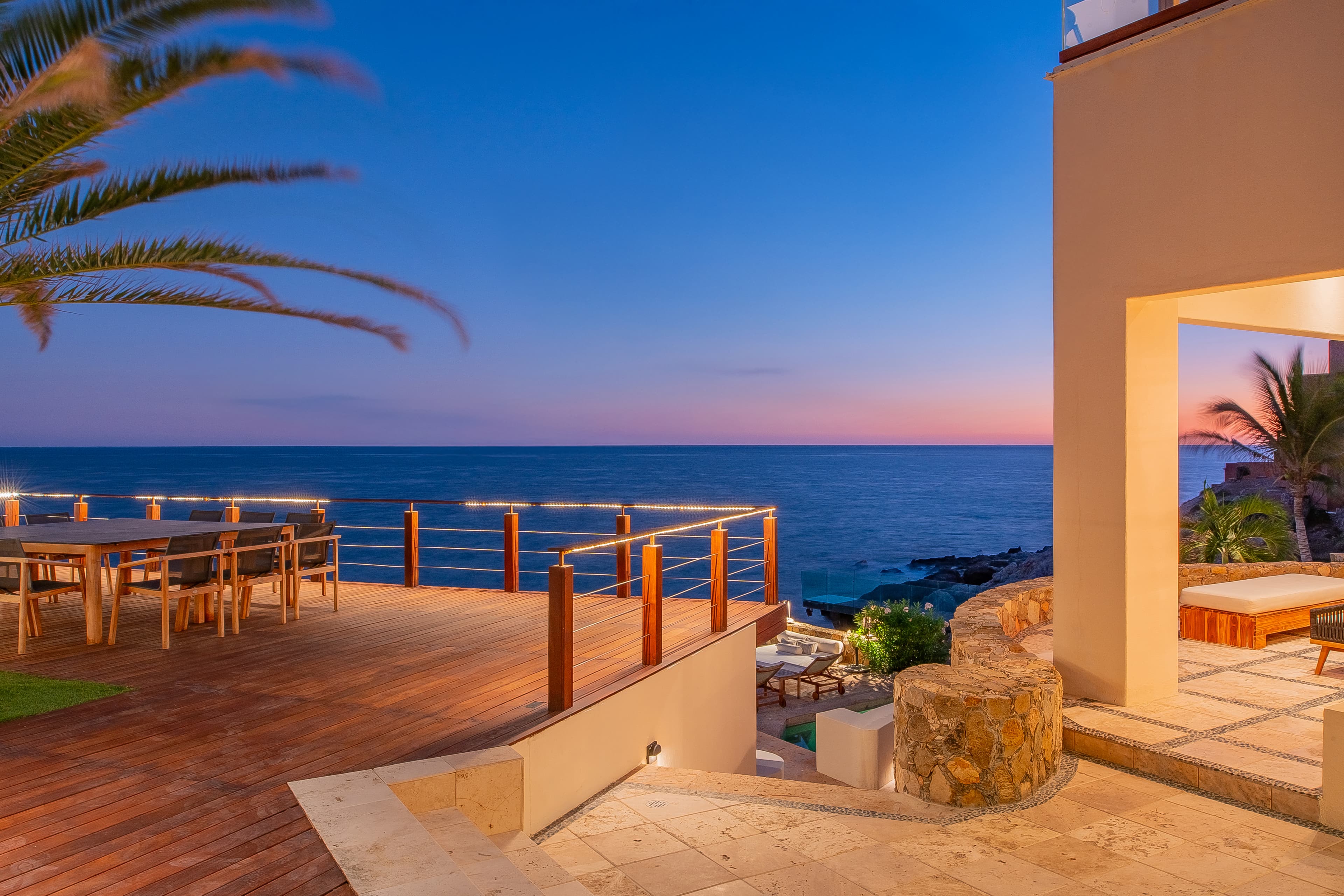 Stunning ocean-view terrace with warm Mediterranean architecture and direct seafront access, ideal for sunset dining and seaside relaxation.